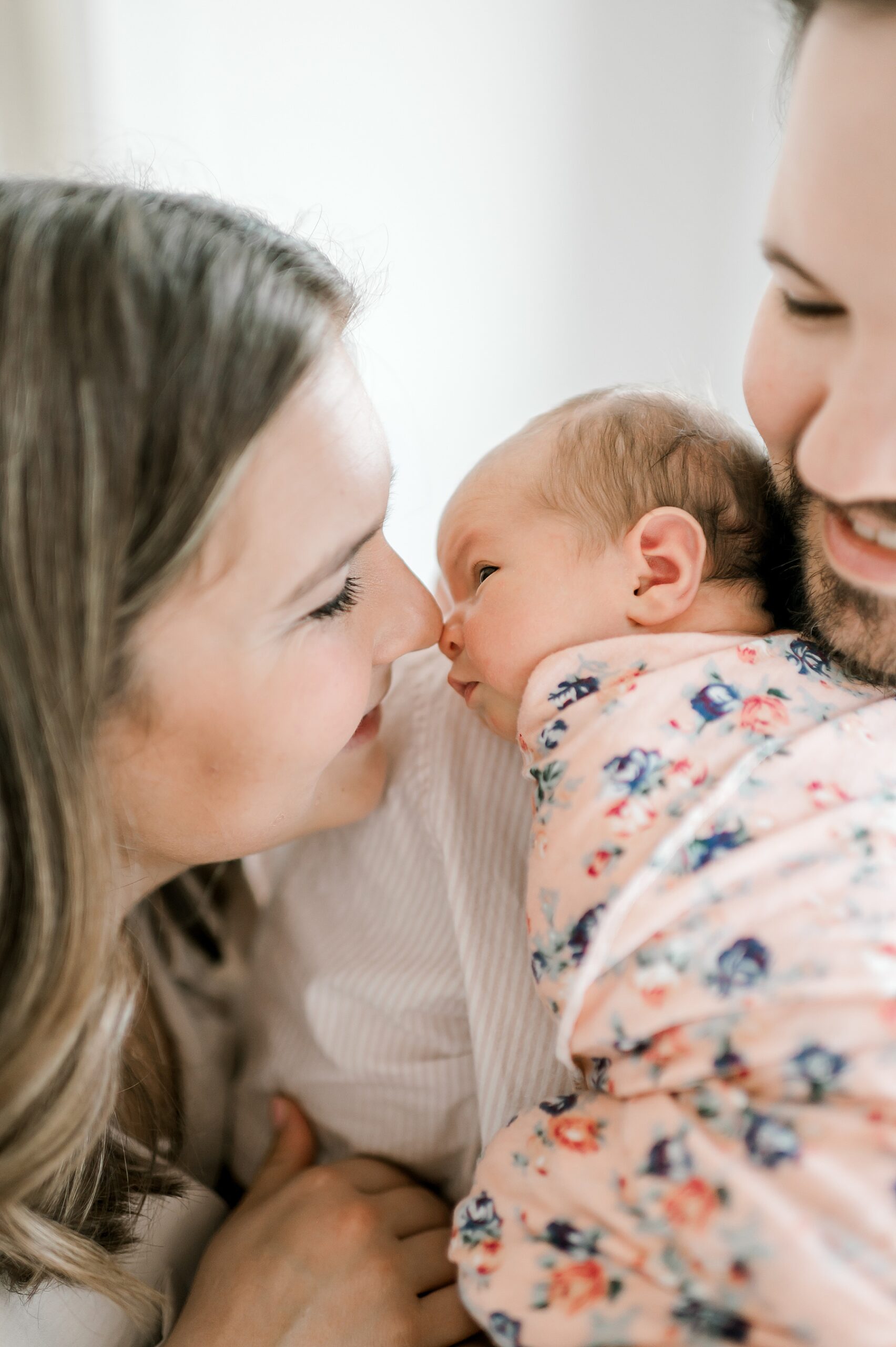 dad holds newborn and mom leans close to baby girl