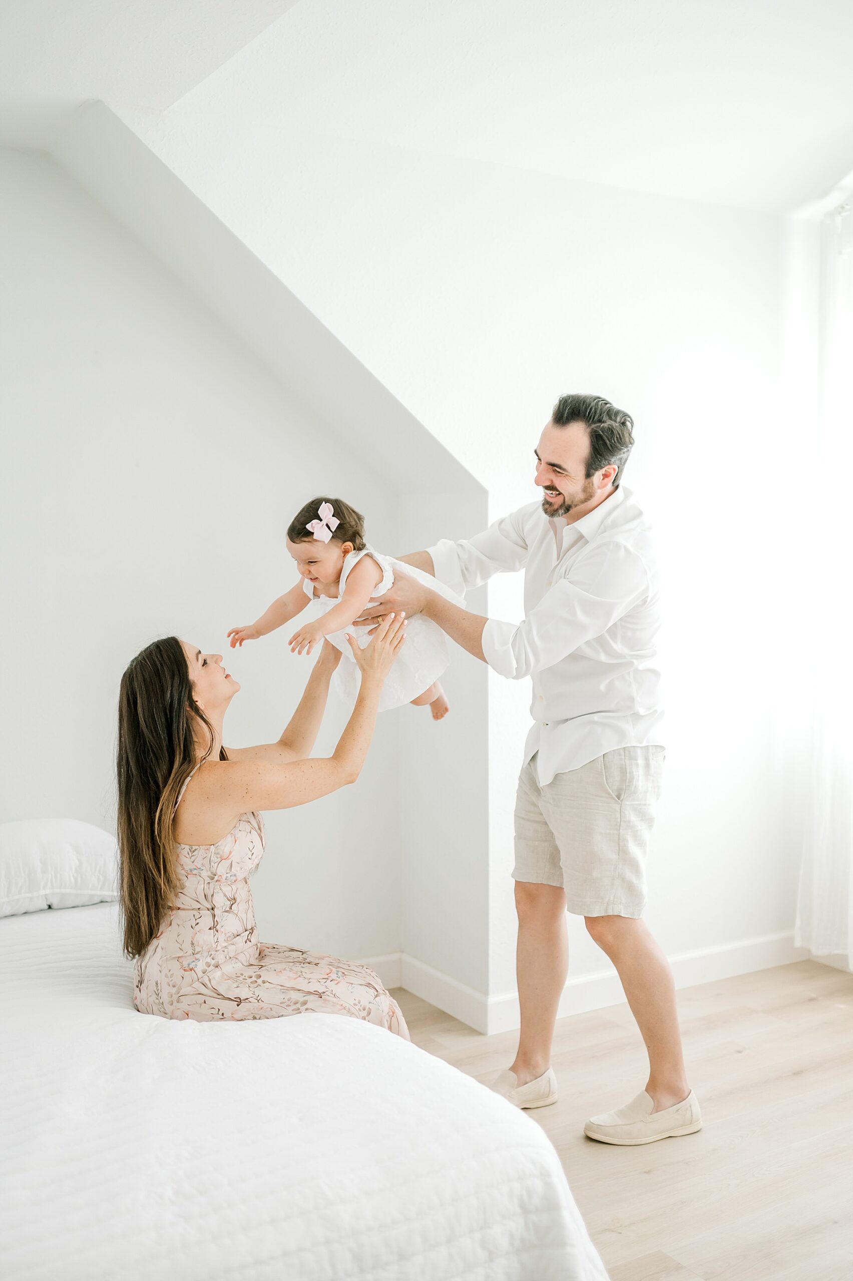 dad hands little girl to her mom