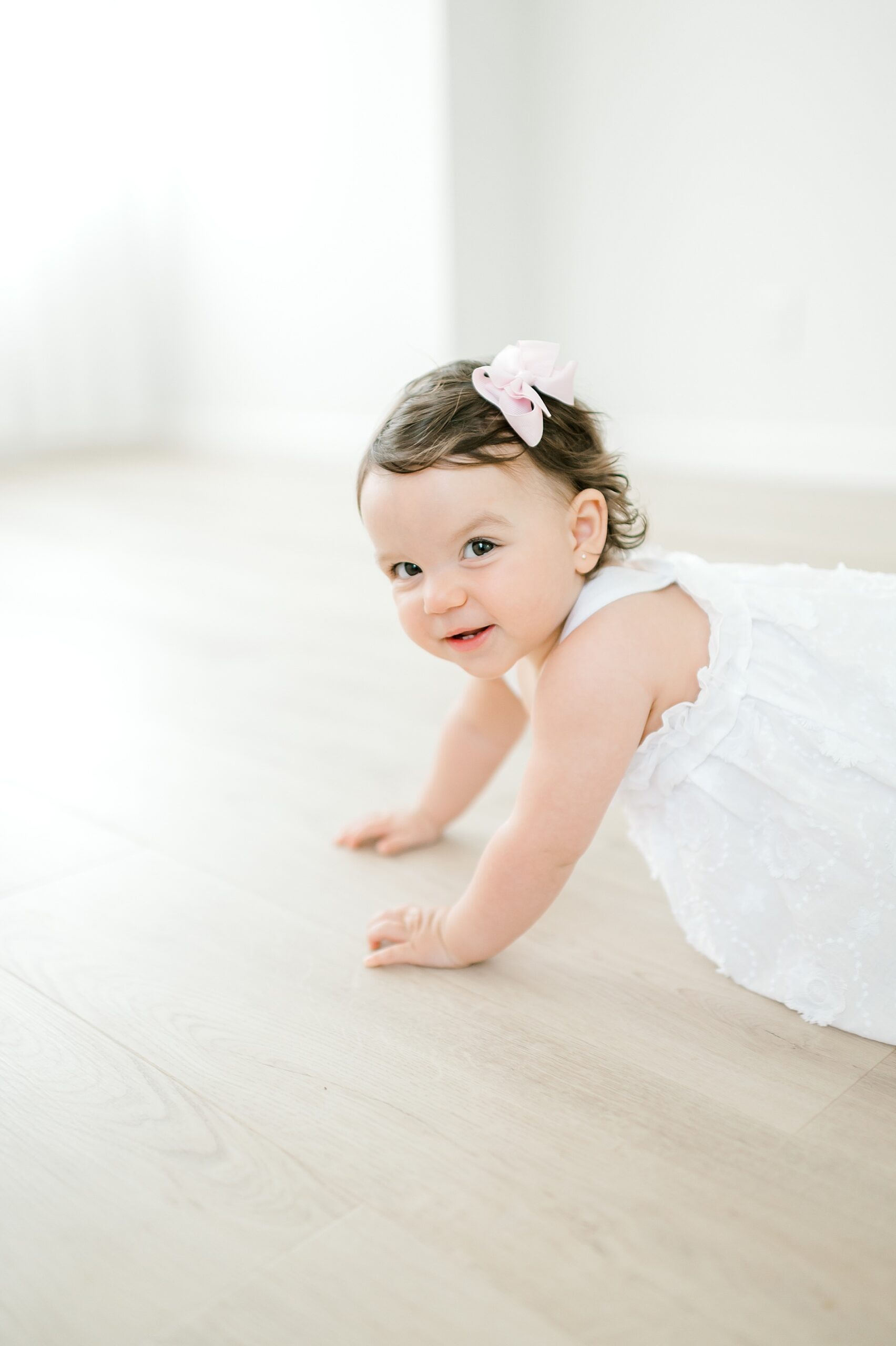 one year old girl crawls around on floor