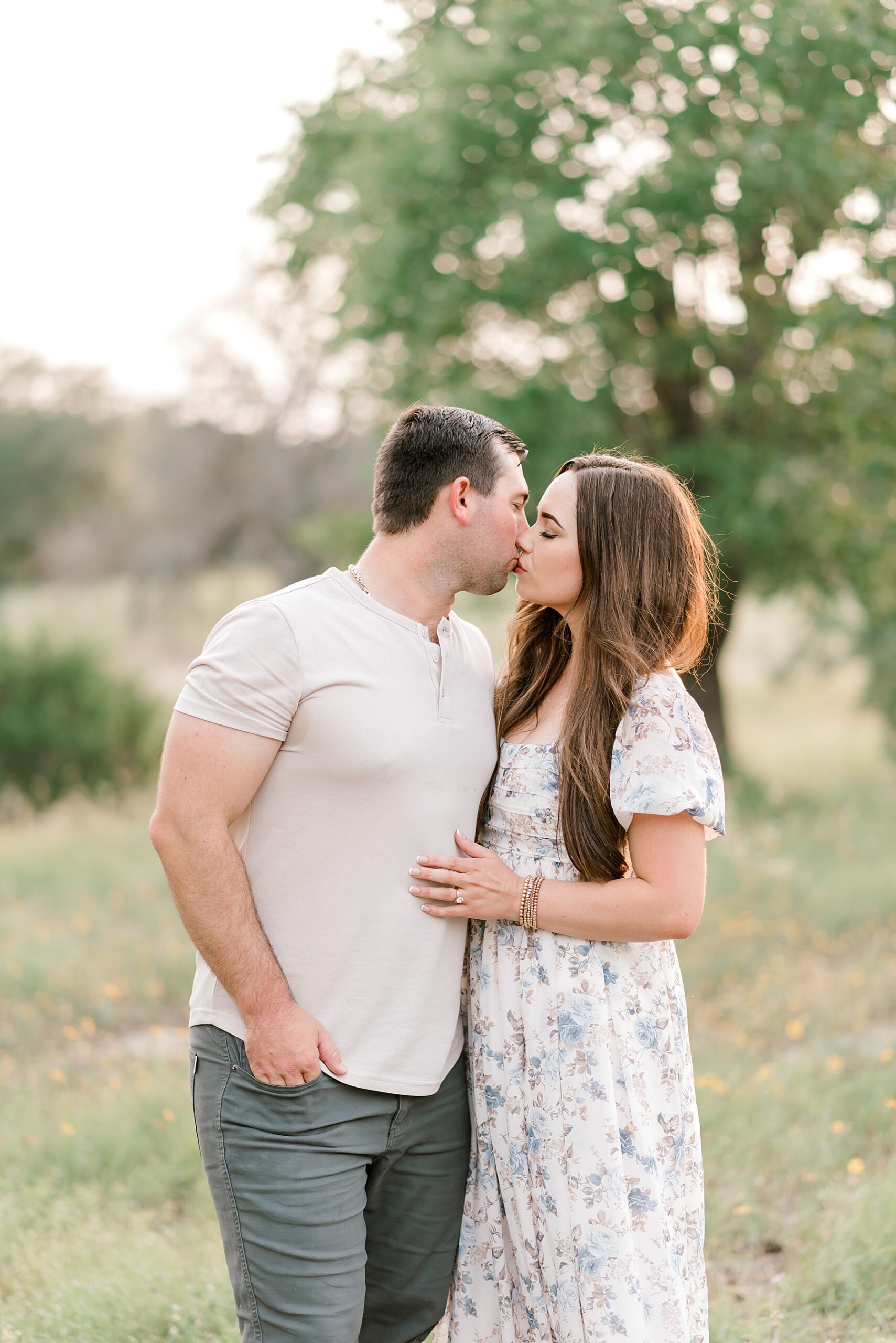 parents kiss at field in Bulverde, TX