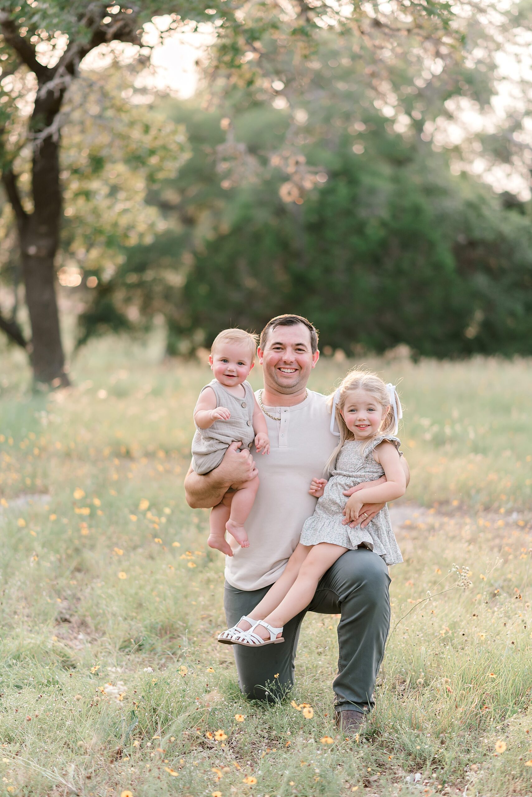 dad holds two kids in arms