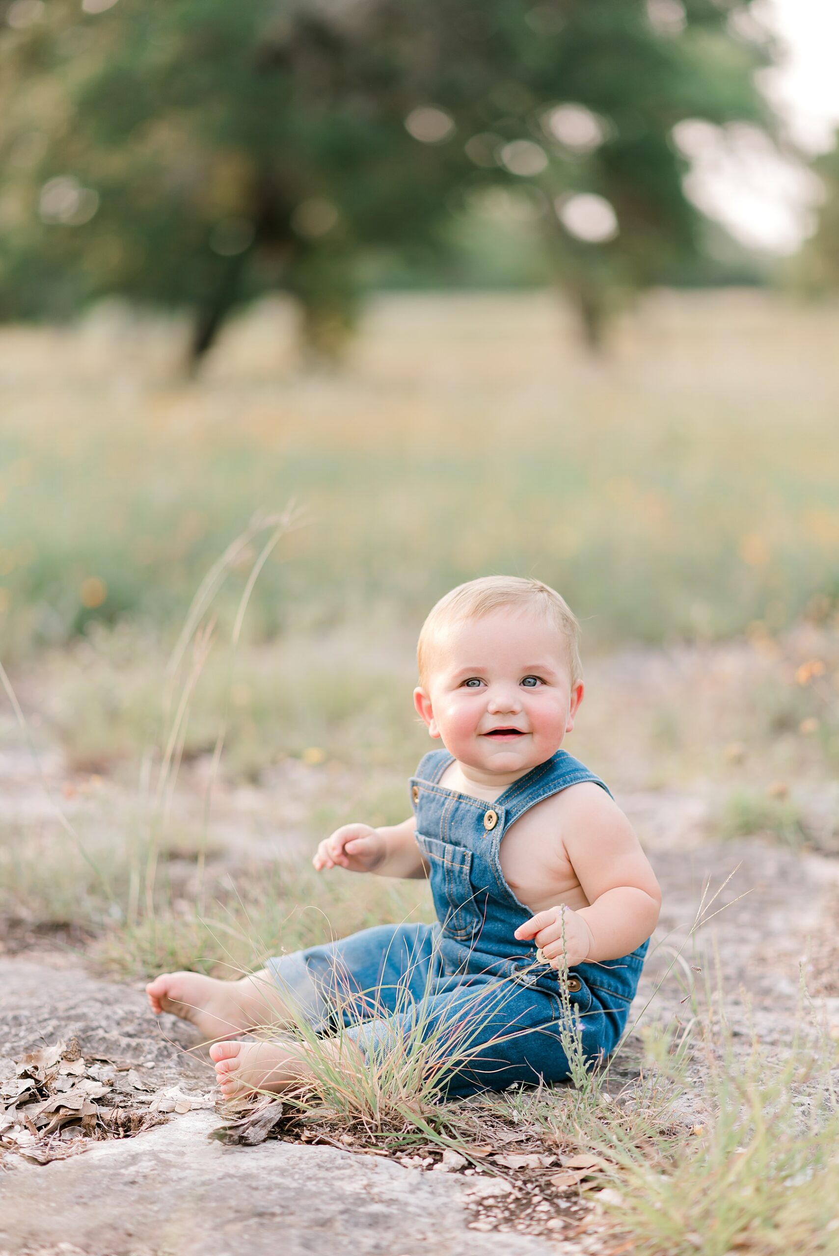 sweet little boy in overalls during sitter session in Bulverde, TX