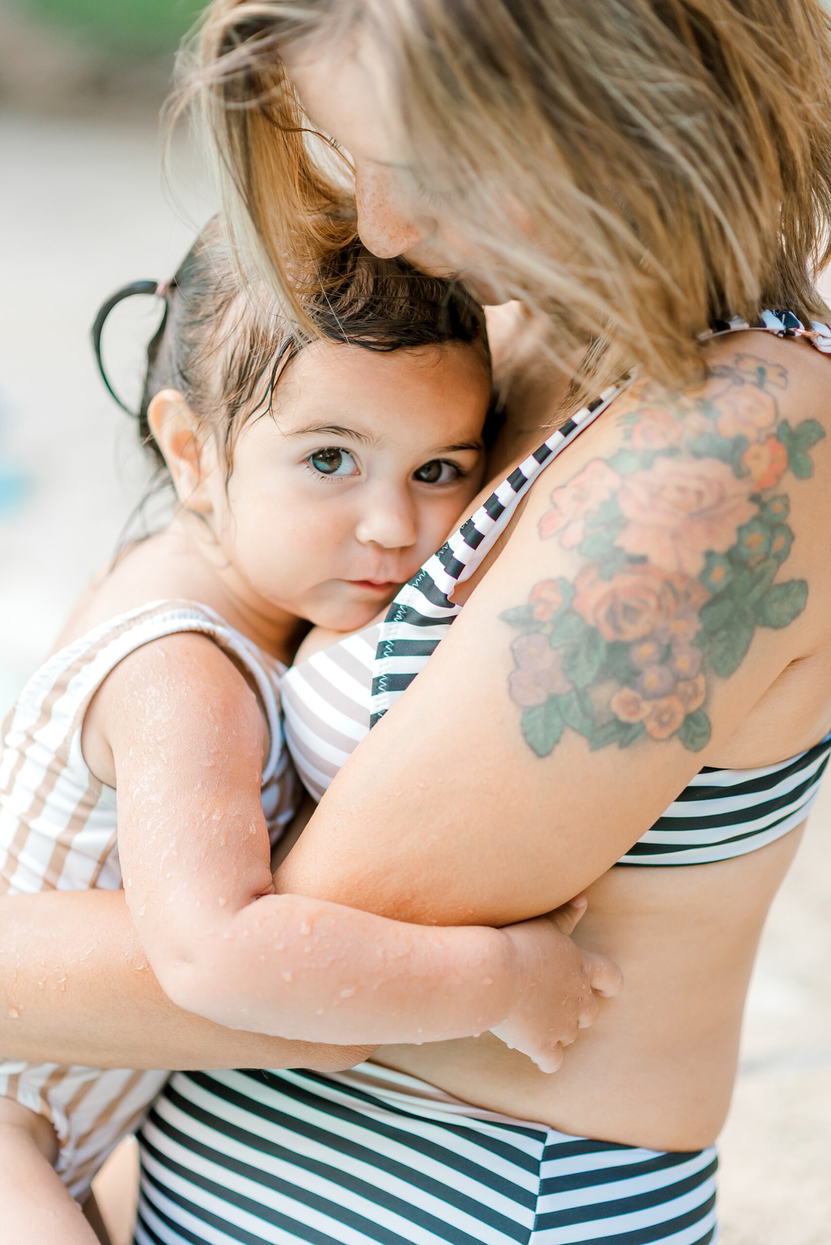 mom holds daughter and kisses her head