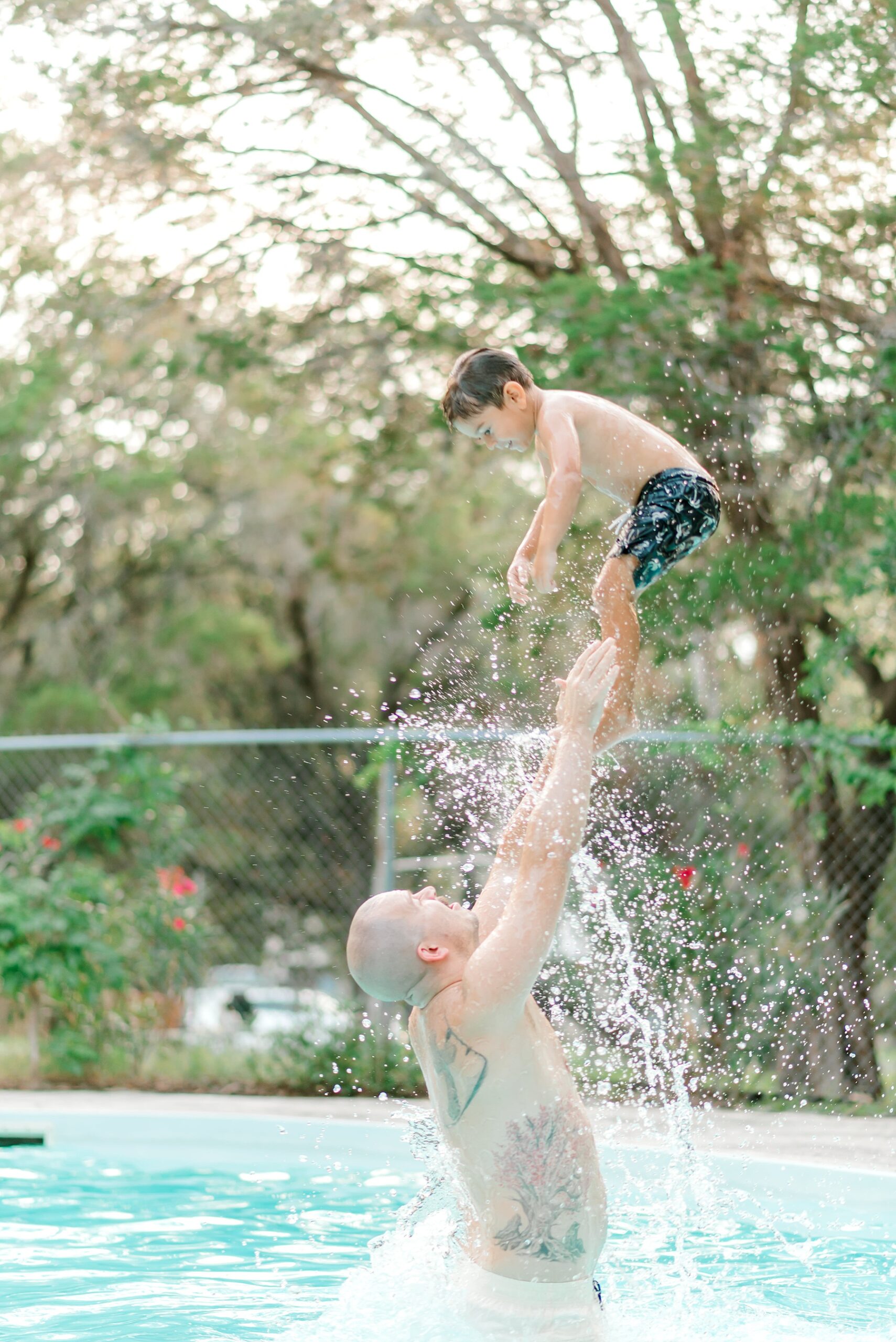 dad plays with son in pool