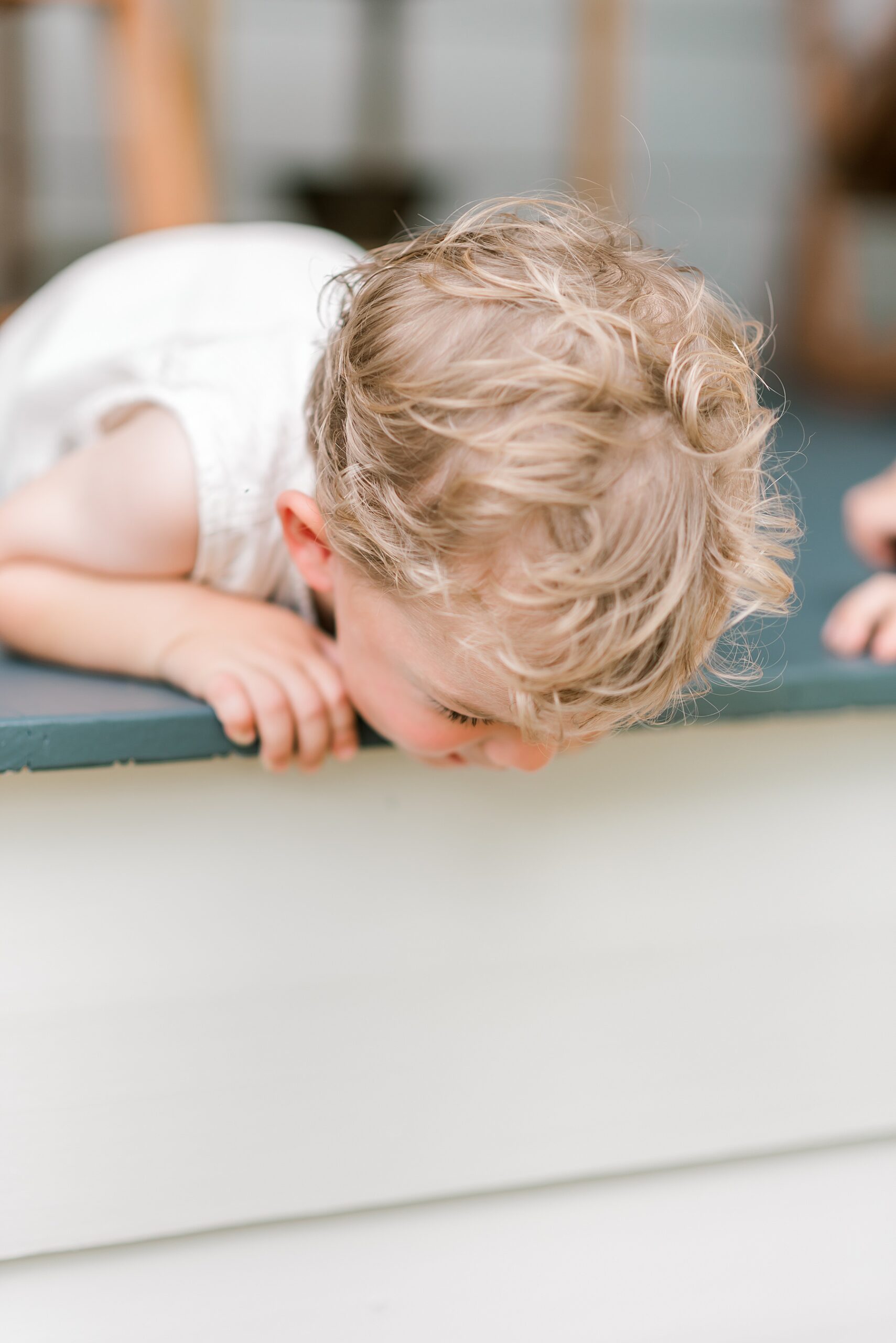 little boy looks over ledge of porch