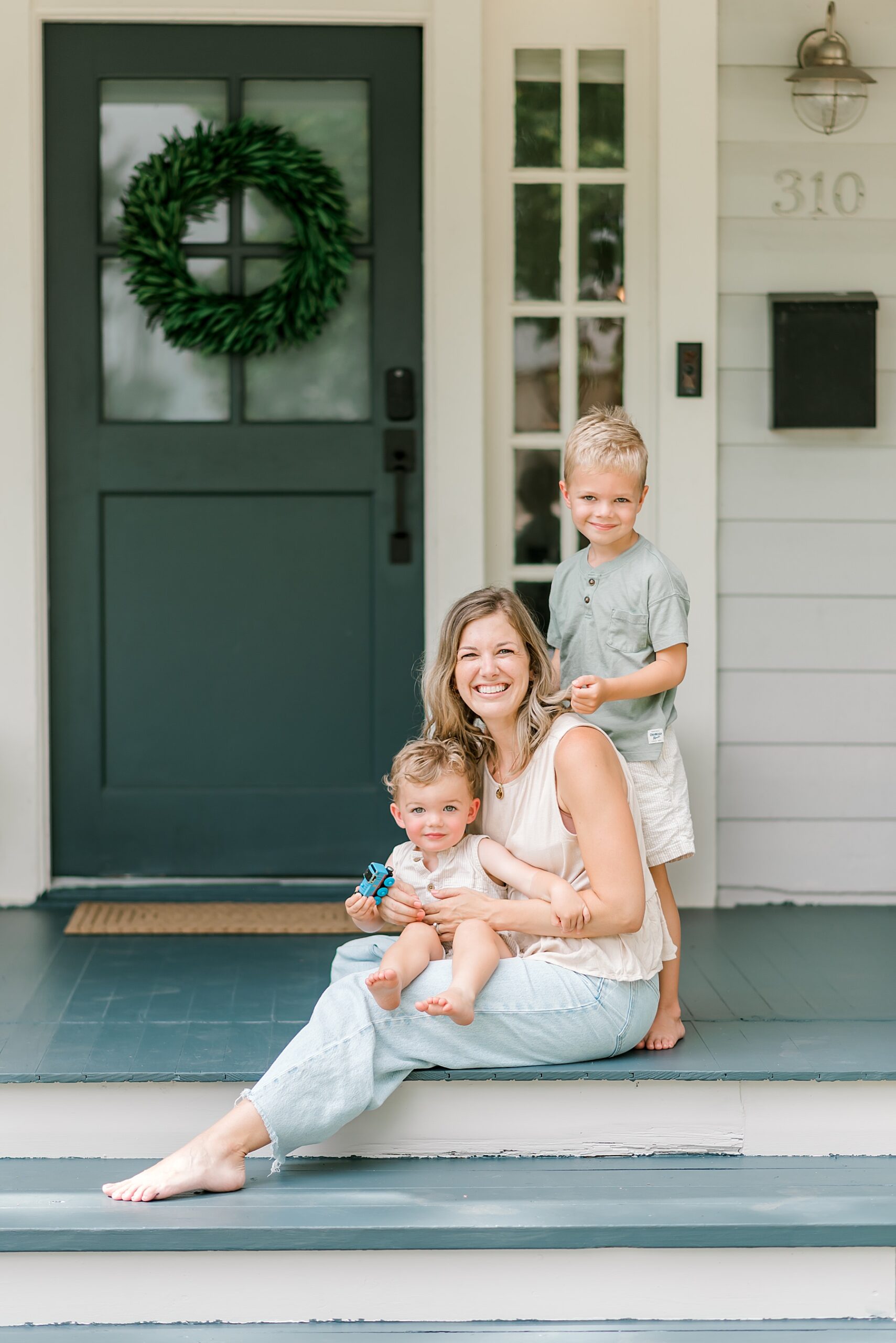 two boys sit with their mom on porch steps