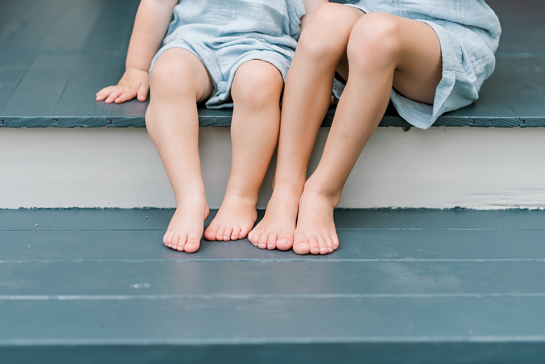 brothers sit together on porch steps 