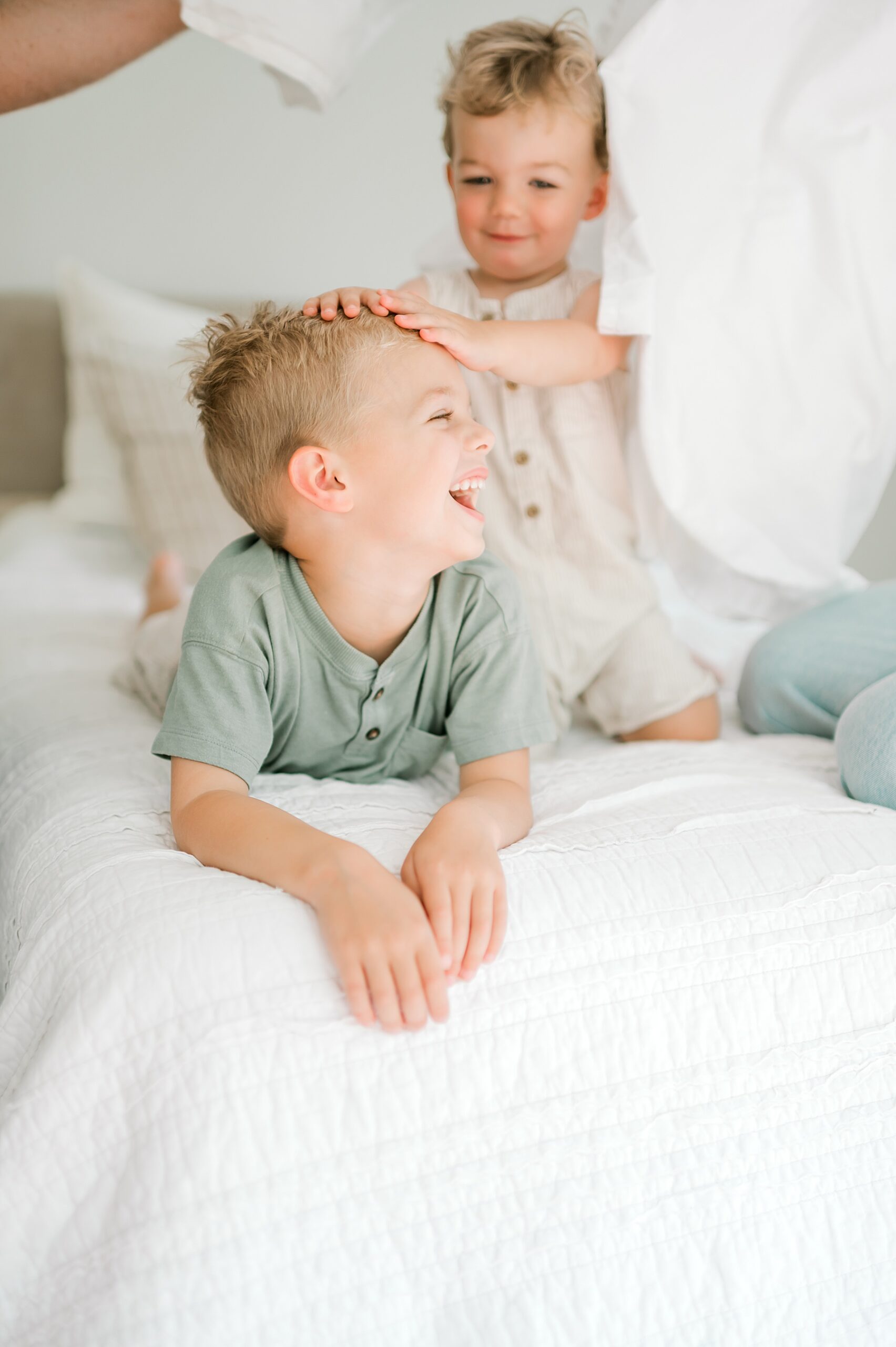 brothers playing on bed during in-home session in Mahncke Park, TX