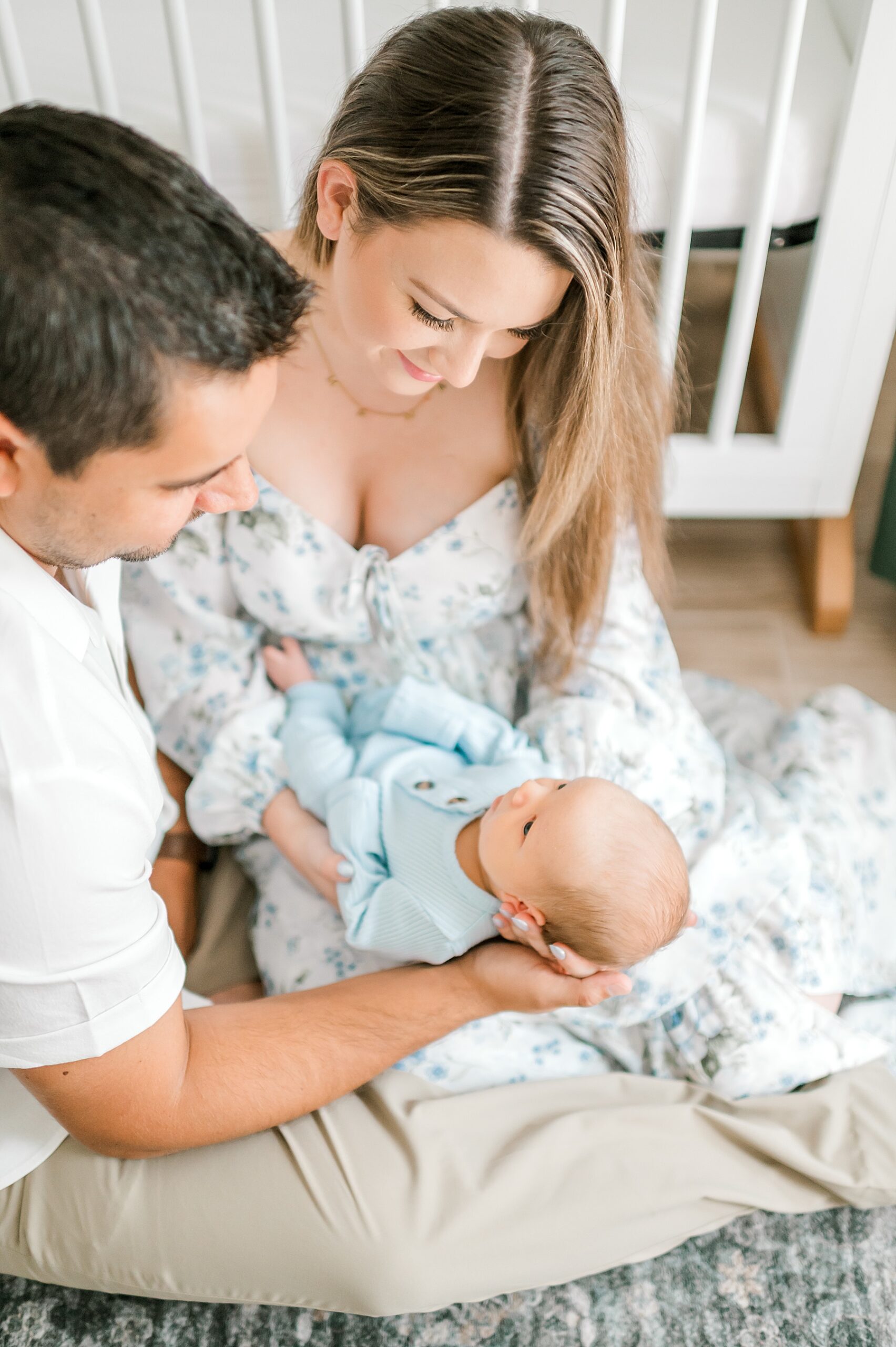 mom in flowy dress holds baby in blue onesie 
