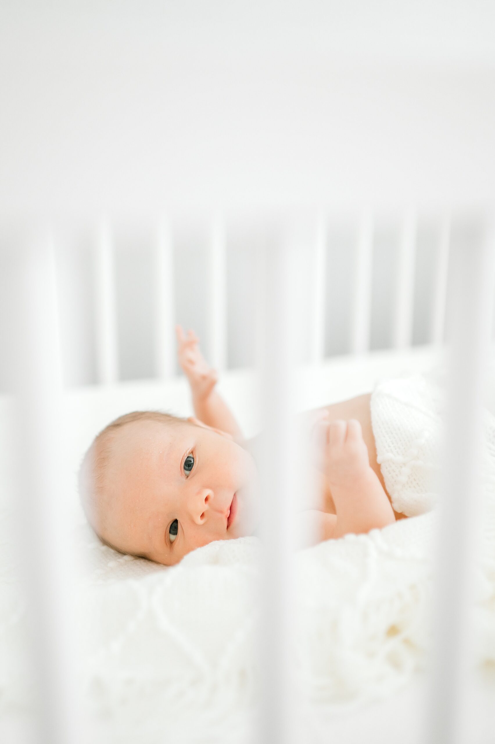 baby lays in crib during lifestyle in-home session