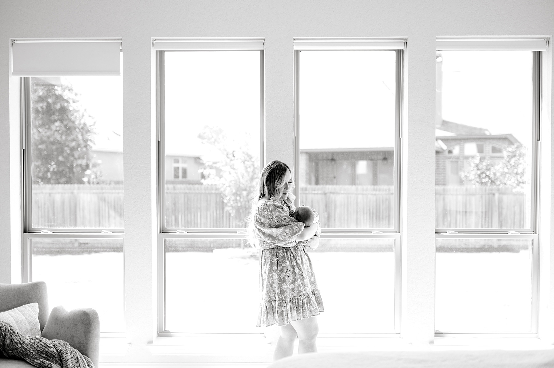 timeless newborn photos of mom holding baby boy by patio doors