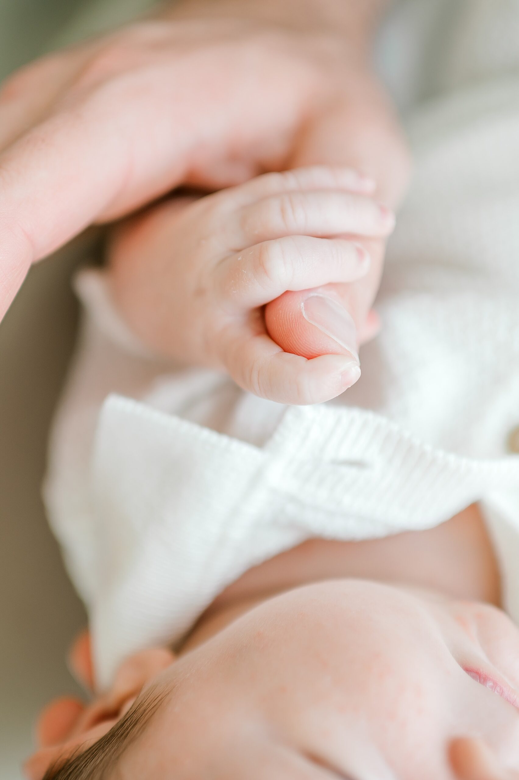 baby grasps parent's finger