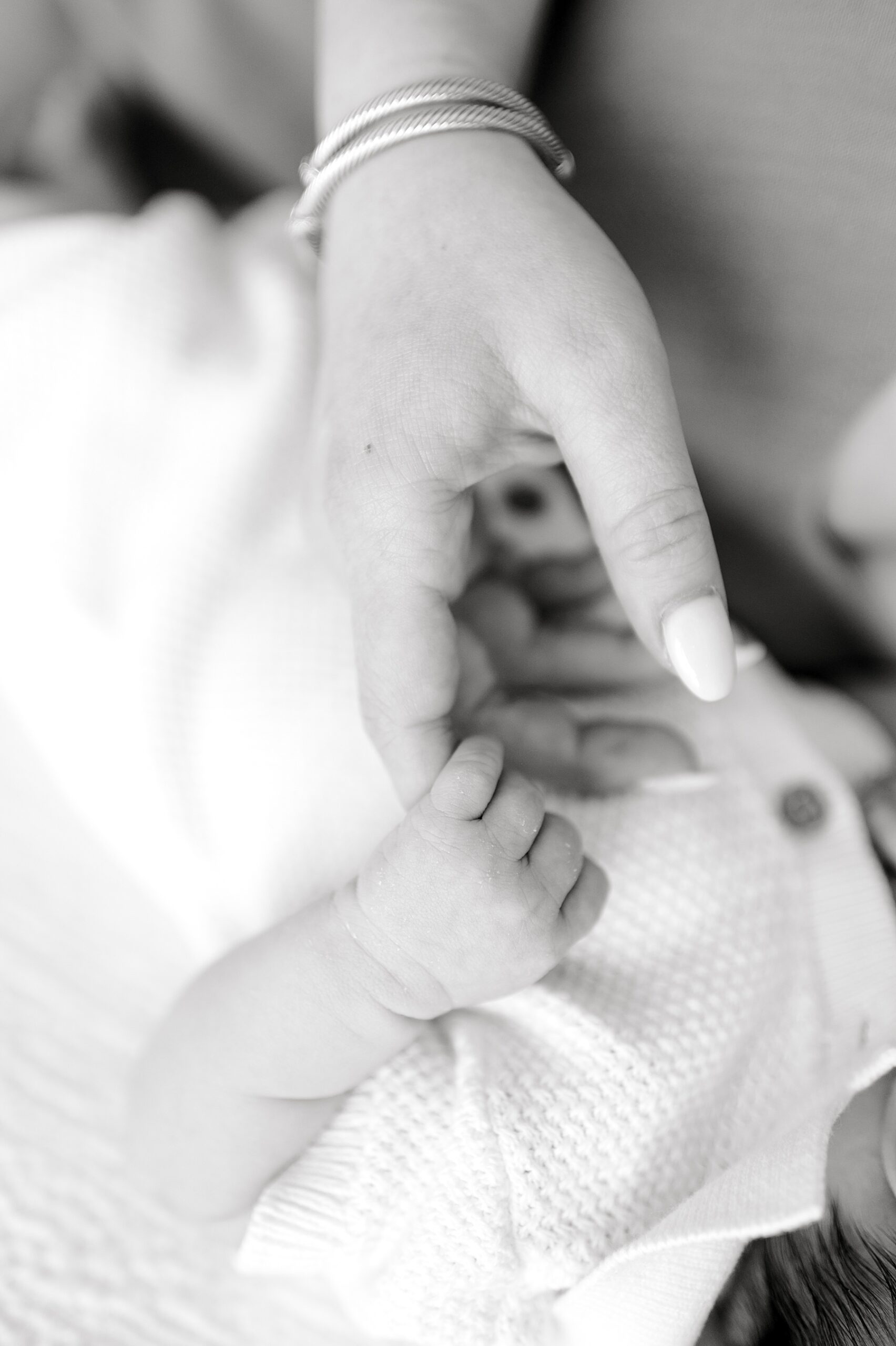 baby holds mom's finger