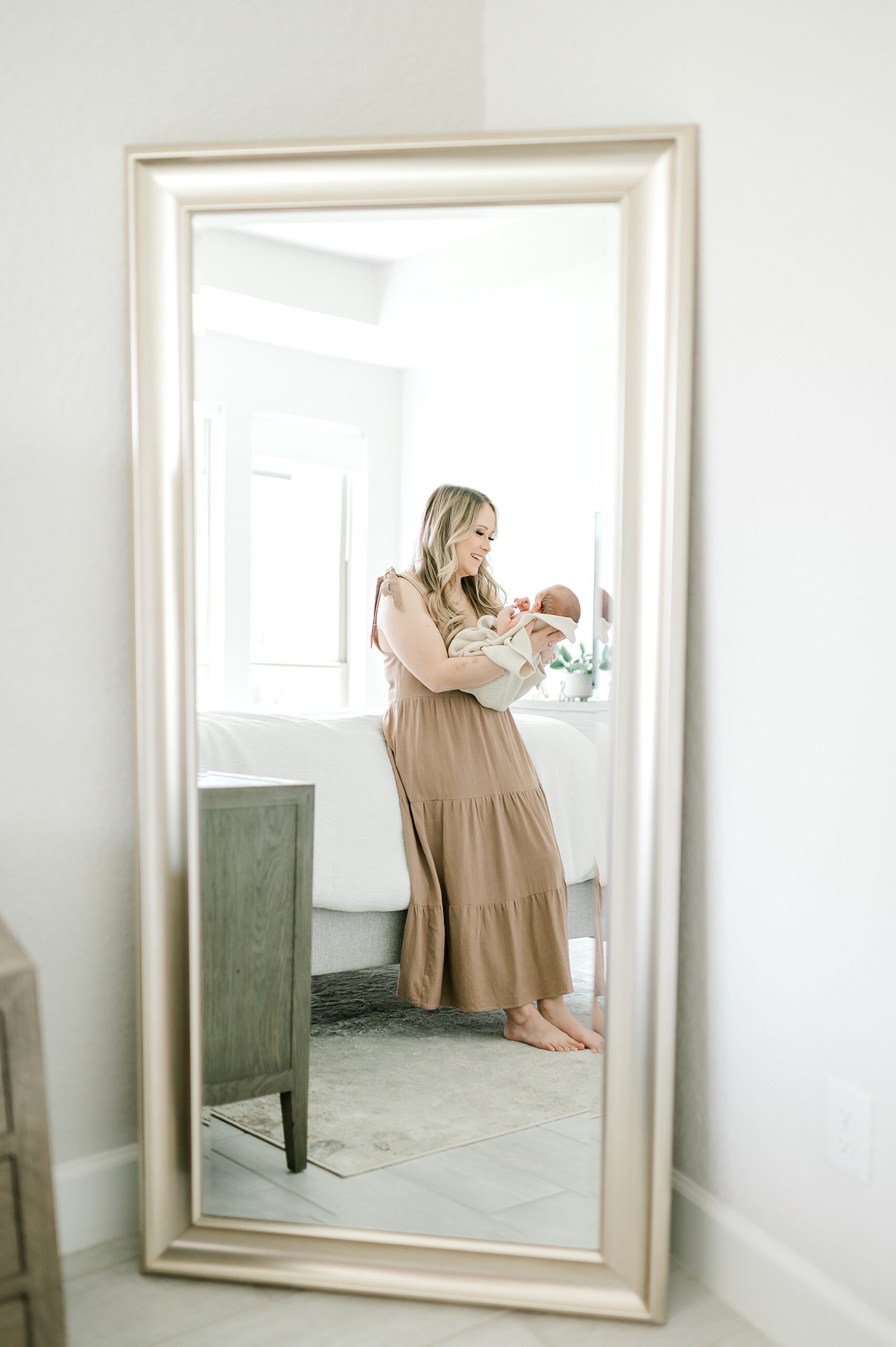 reflection in mirror of mom holding newborn boy