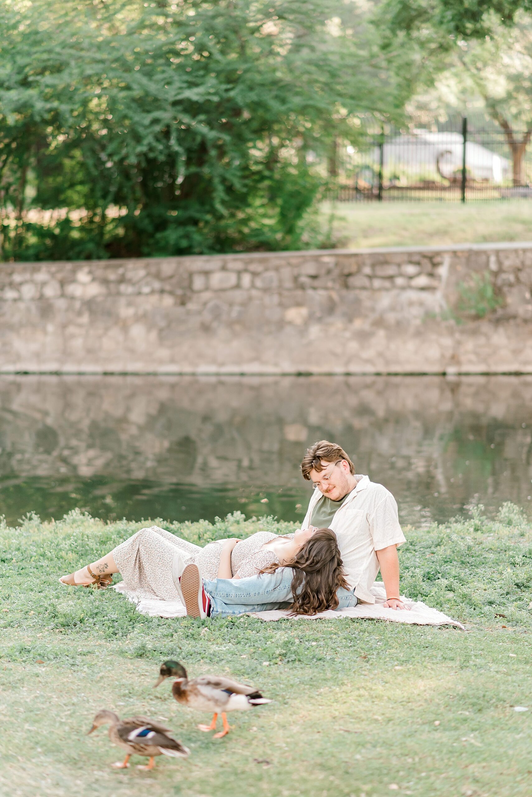 Timeless and sweet maternity photos of couple sitting together at Brackenridge park Celebrating the Journey to Motherhood 