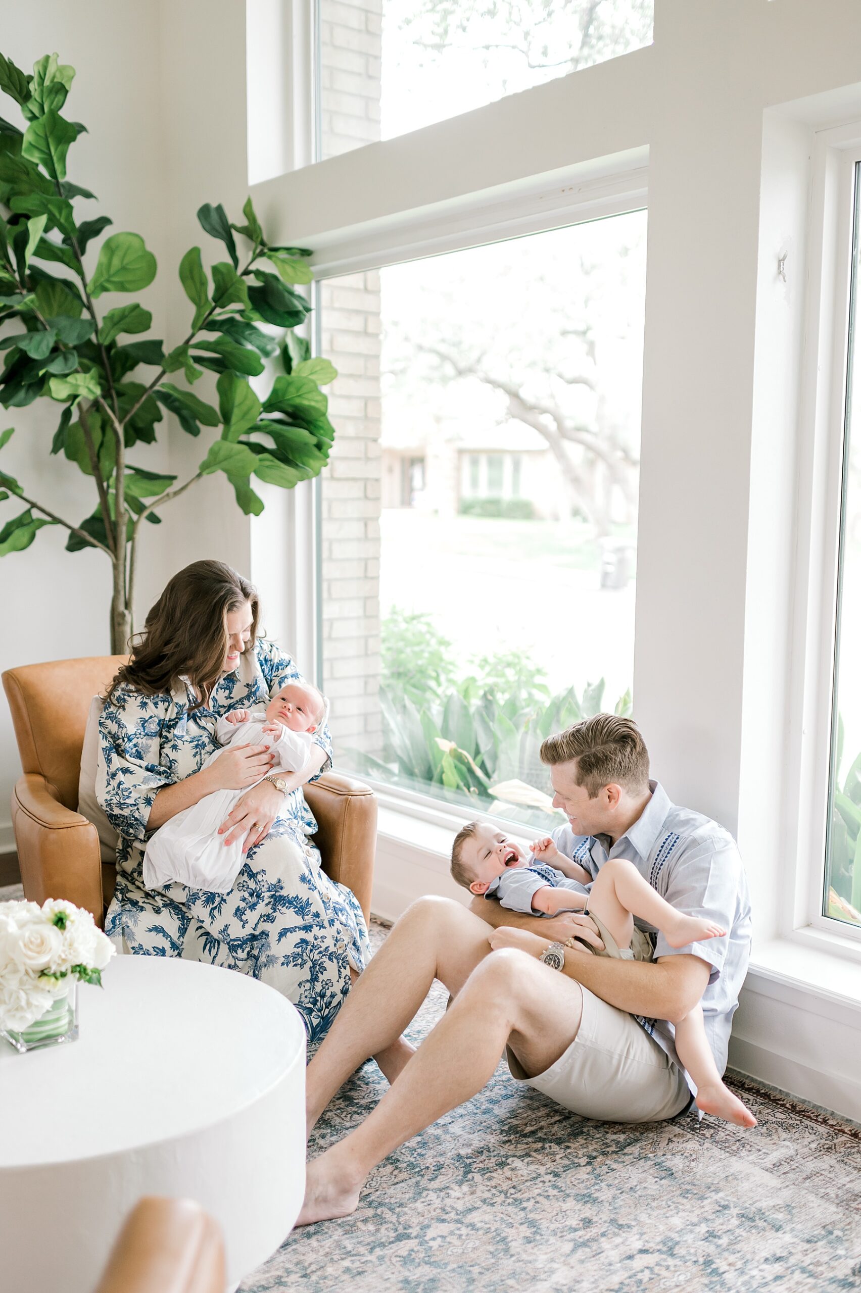 mom holds newborn while dad holds older brother