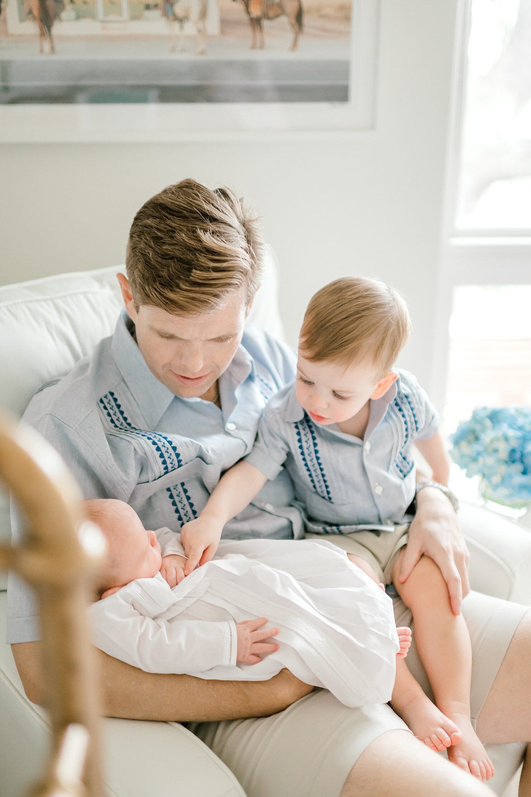 dad holds his two sons in lap