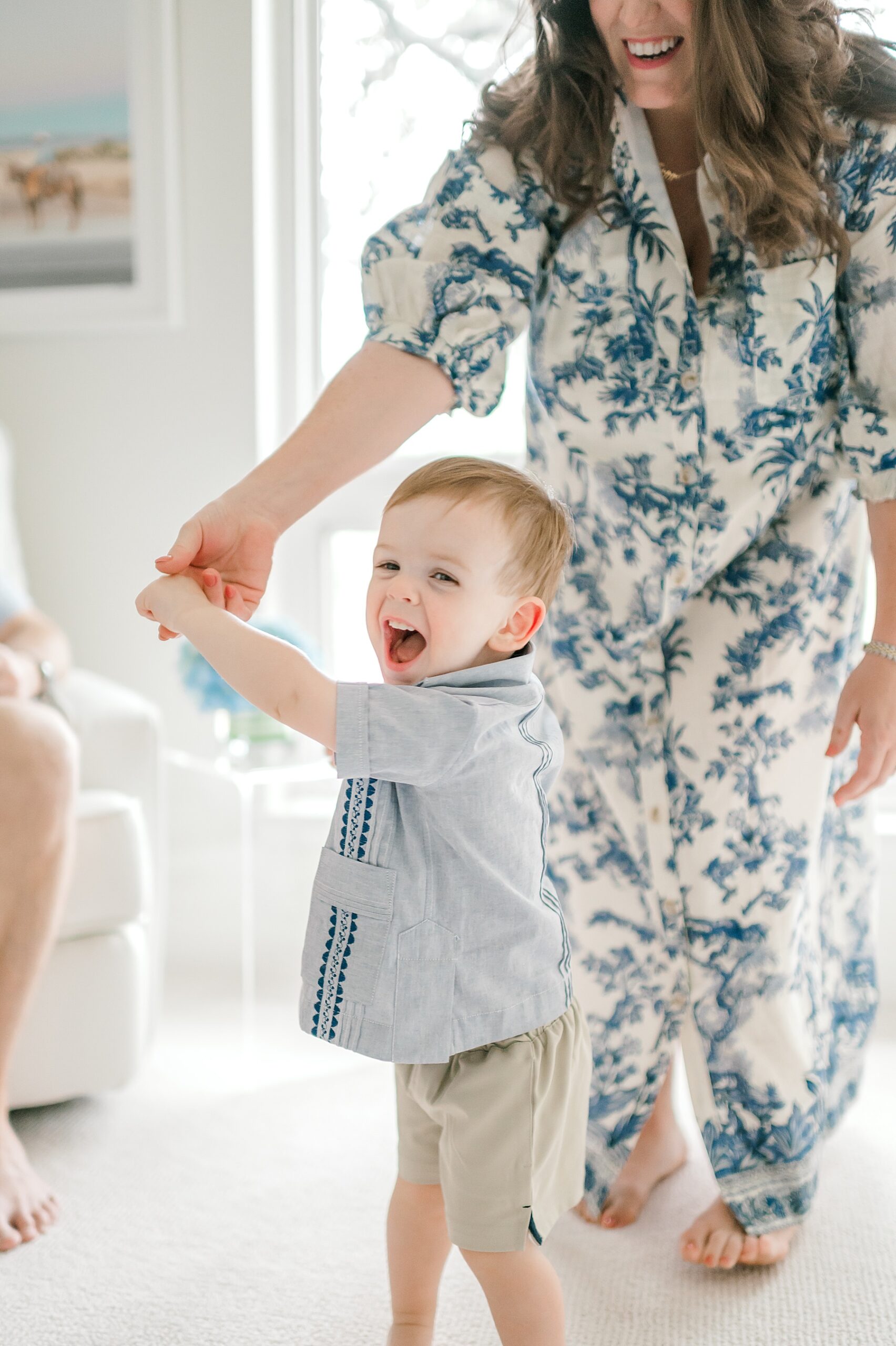mom plays with older son in newborn's nursery