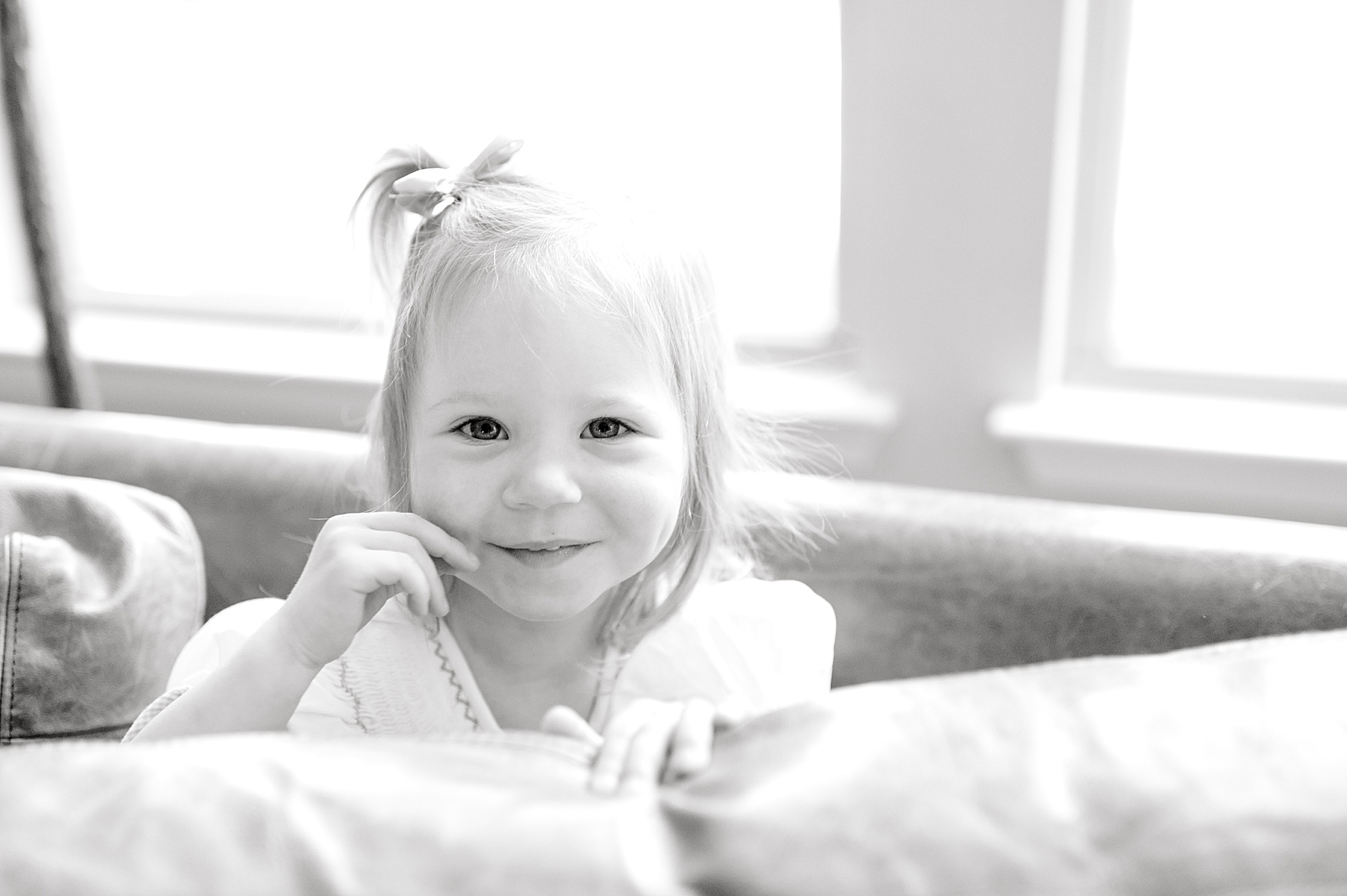 big sister hides behind couch 