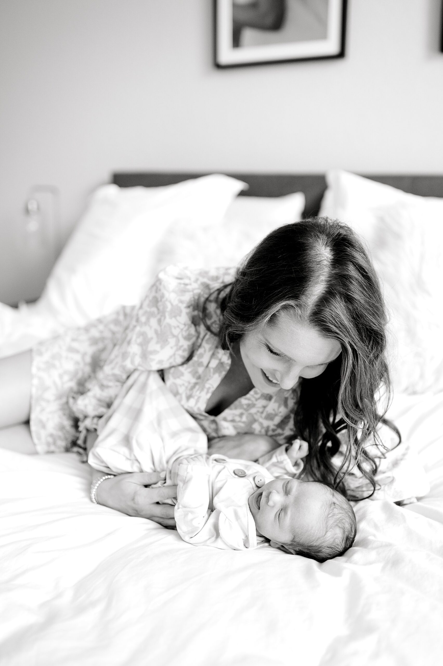 timeless newborn photos of mom laying down on bed with newborn 