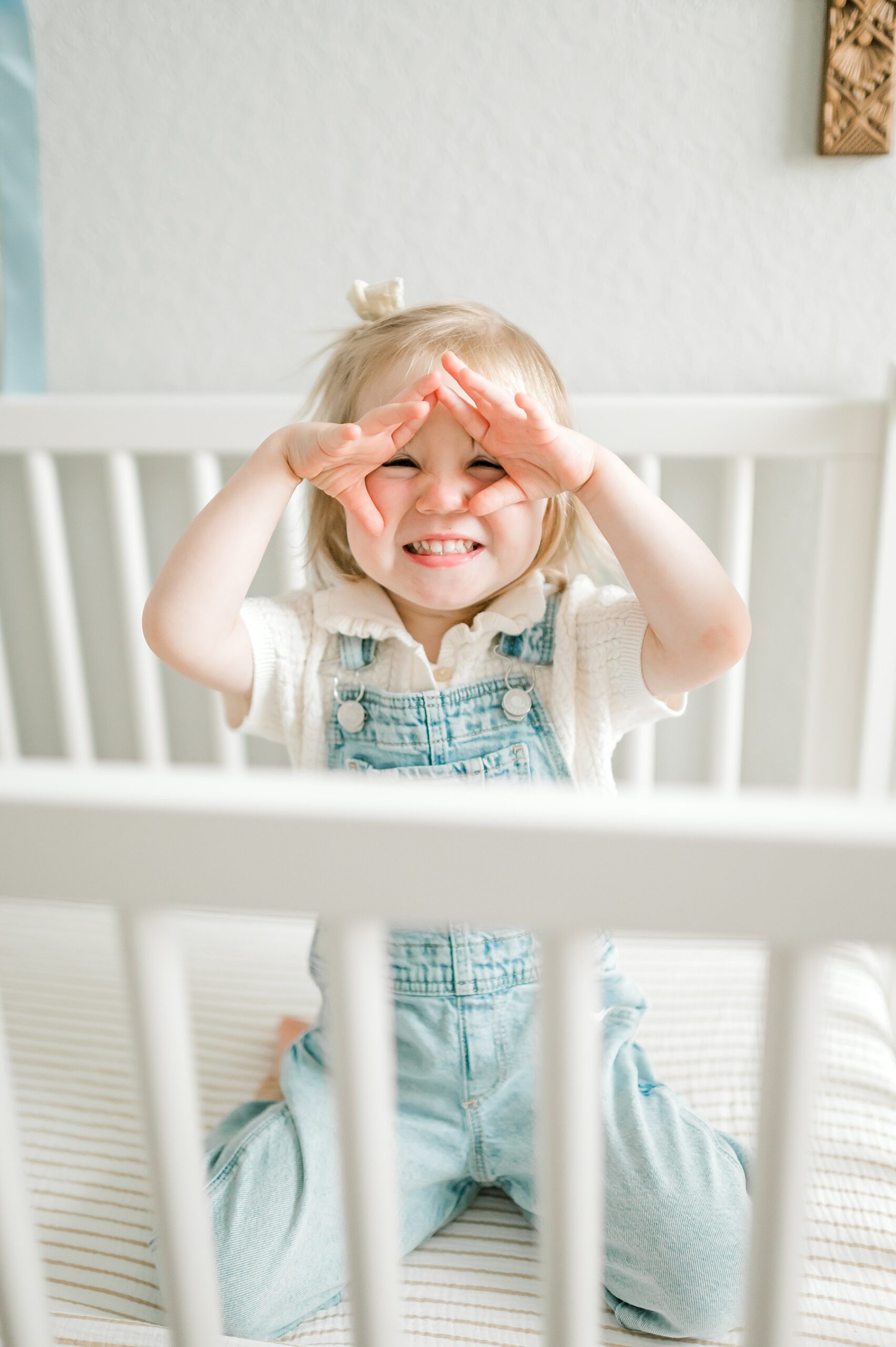 fun and candid photo of big sister in brother's crib | Why I Love Including Toddlers in Newborn Sessions