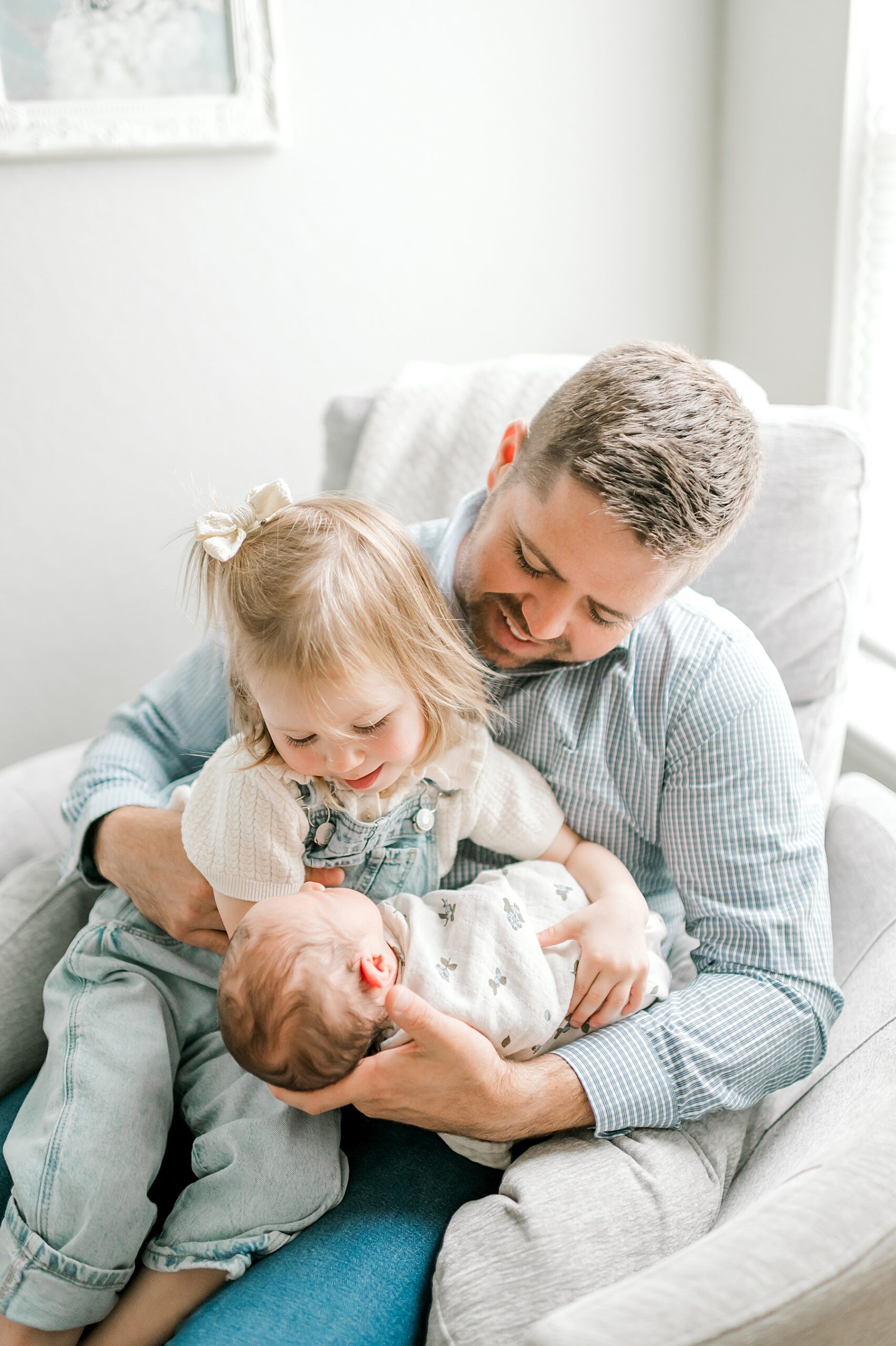 dad holds his daughter and newborn boy
