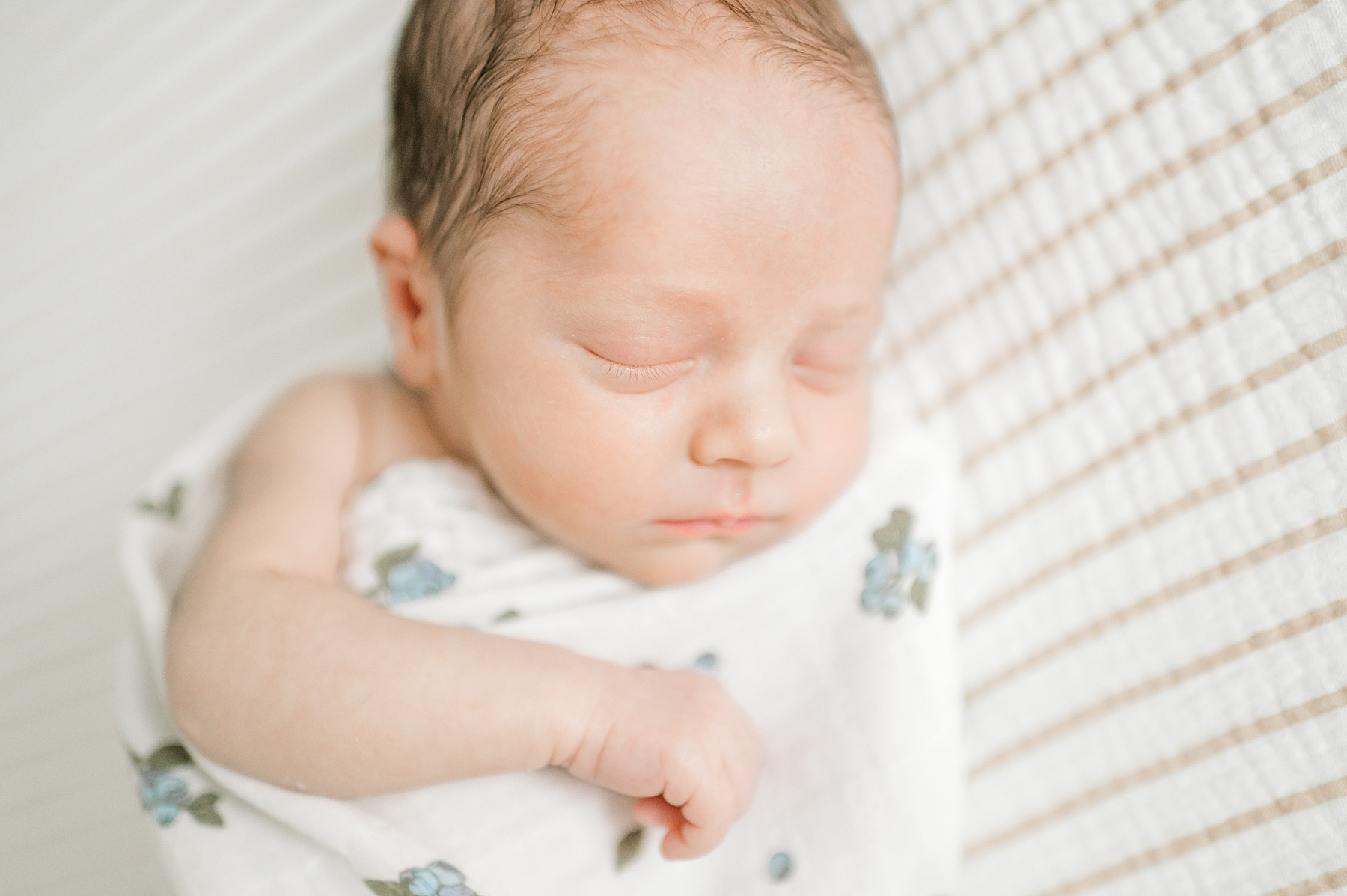 newborn boy sleeps soundly swaddled in blanket