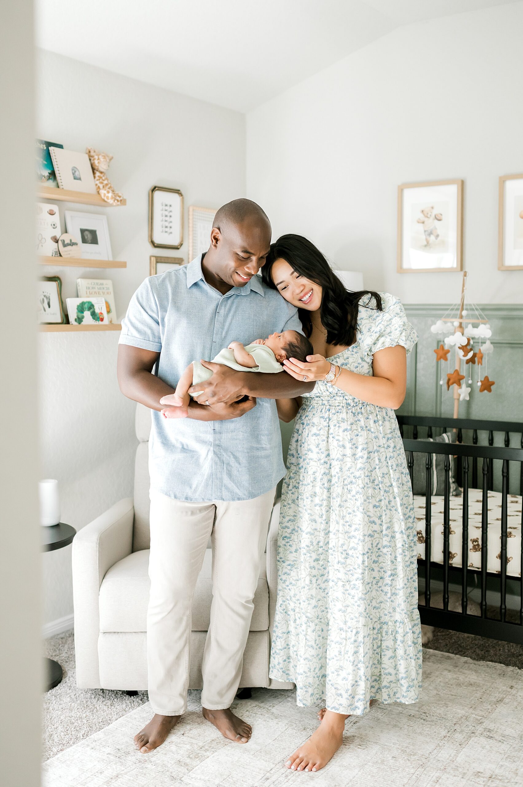 parents hold newborn in nursery