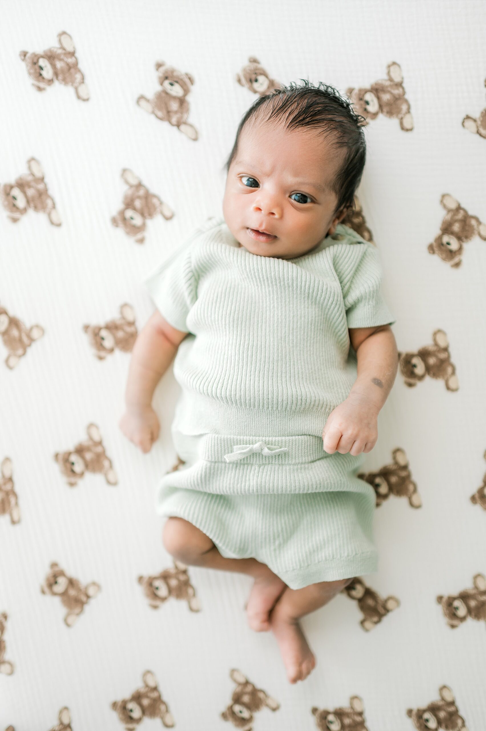 adorable newborn boy in light green outfit