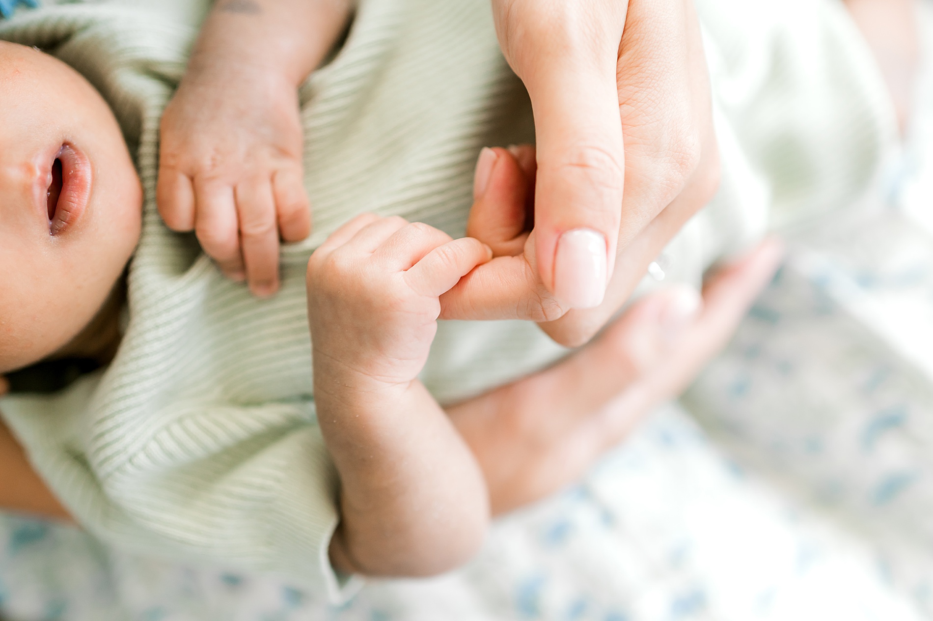 newborn holds mom's fingers