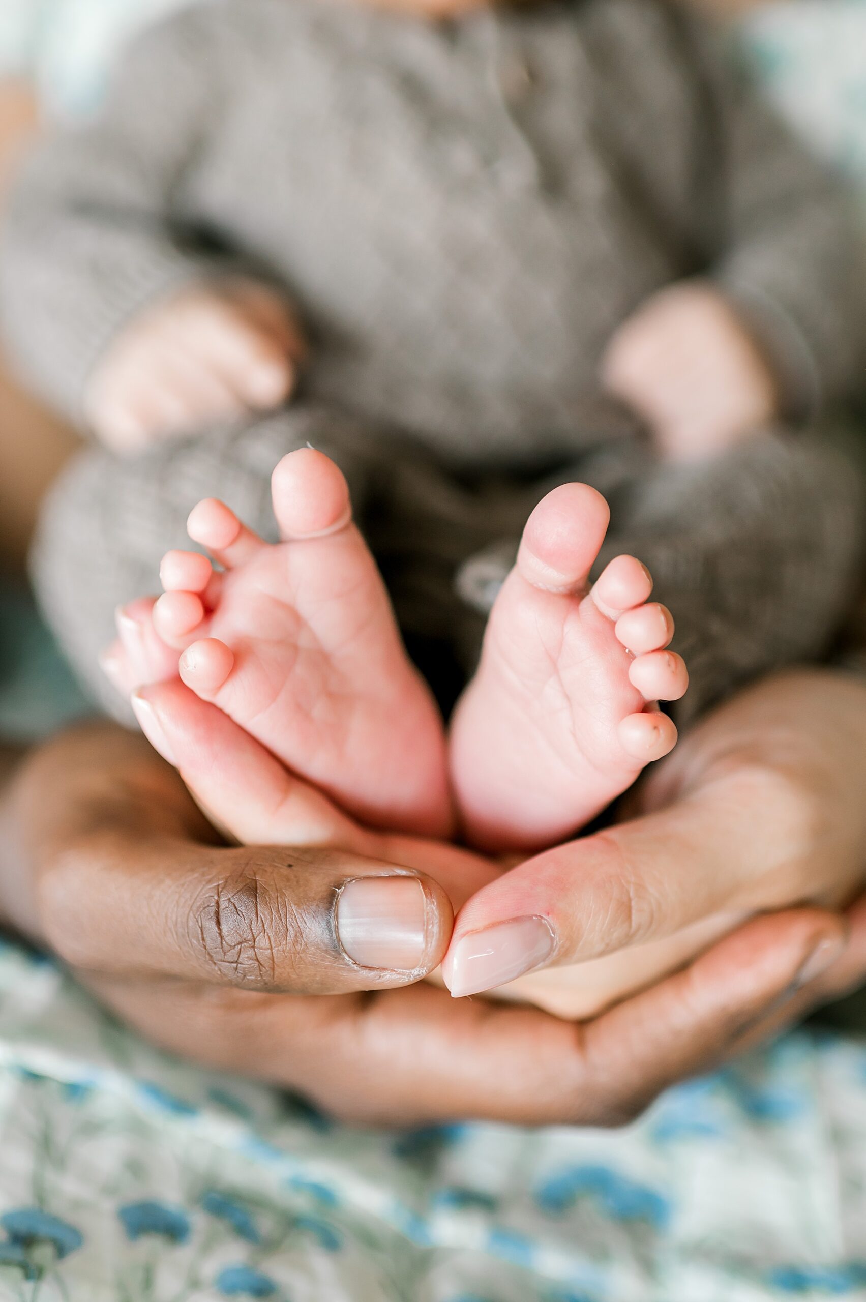 parents hands cradle newborn feet