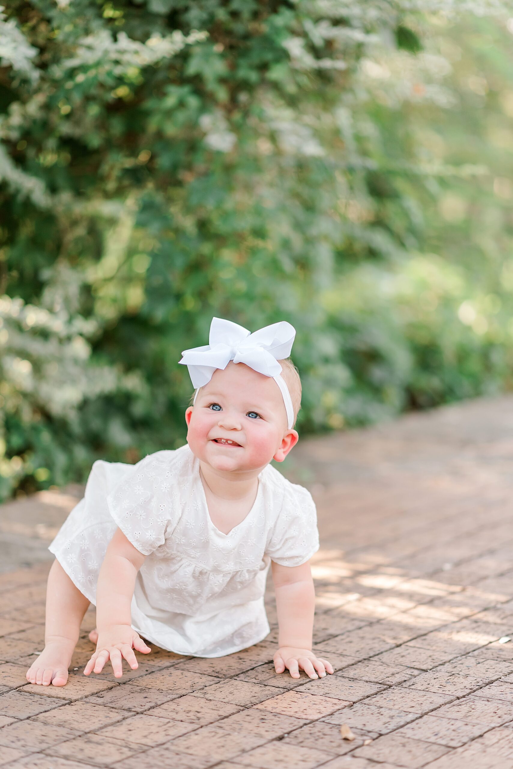 little girl crawls around during outdoor family maternity session in San Antonio 