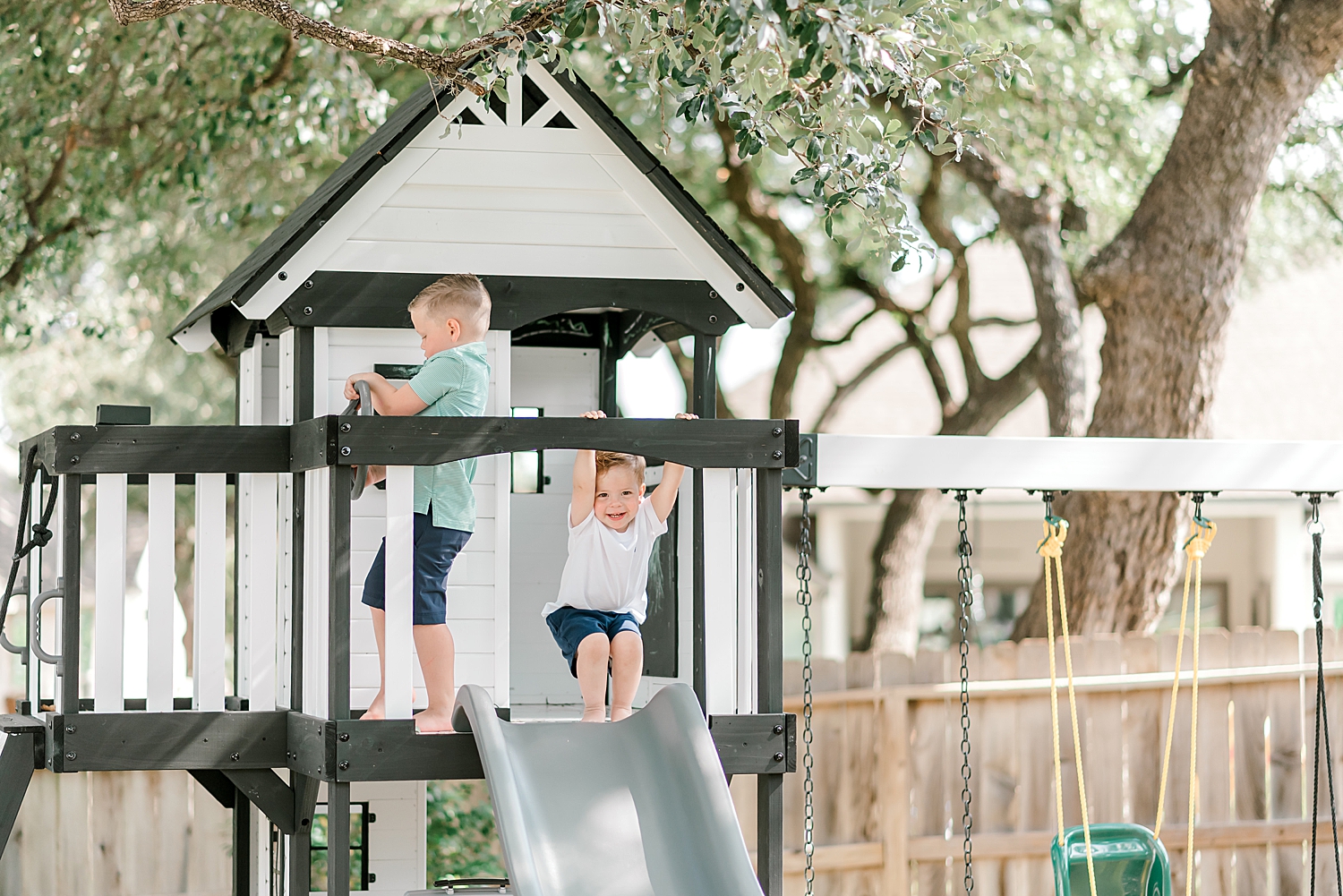 Little boys playing outside on swing set during in home Boerne TX session