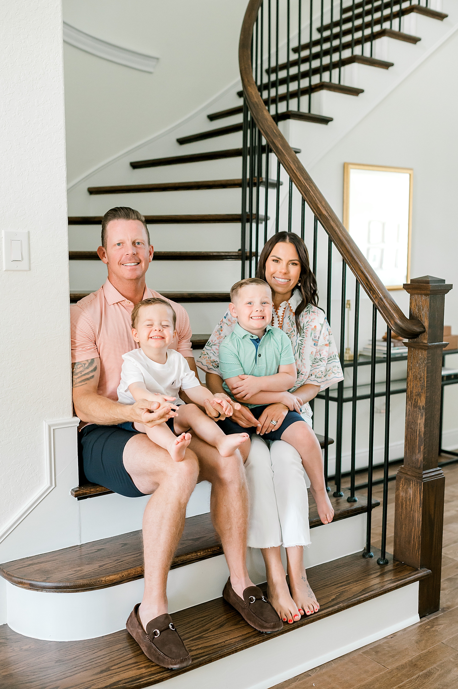 family of four sits on staircase | What to Expect at Your In-Home Family Session