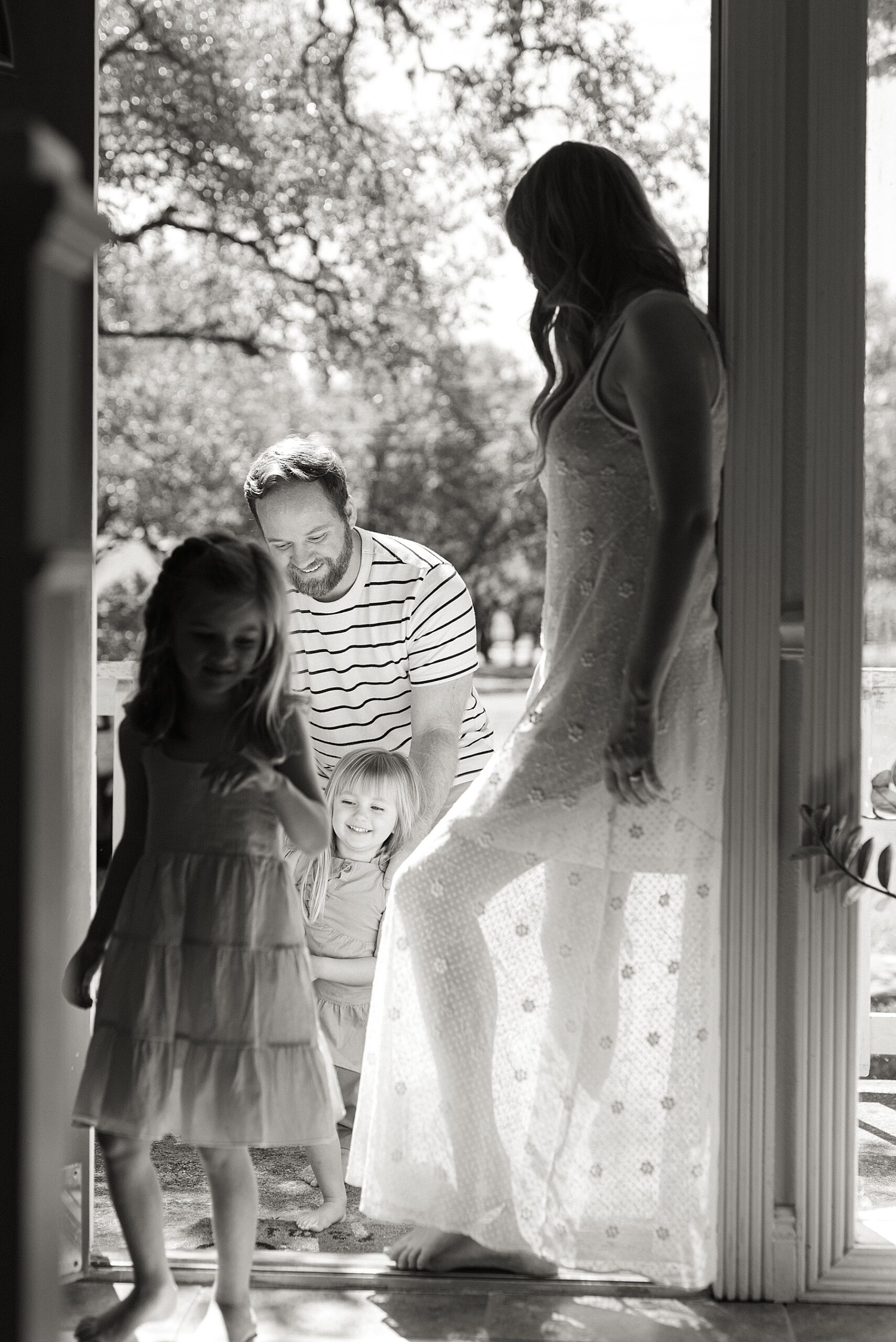 mom leans against doorway with family 