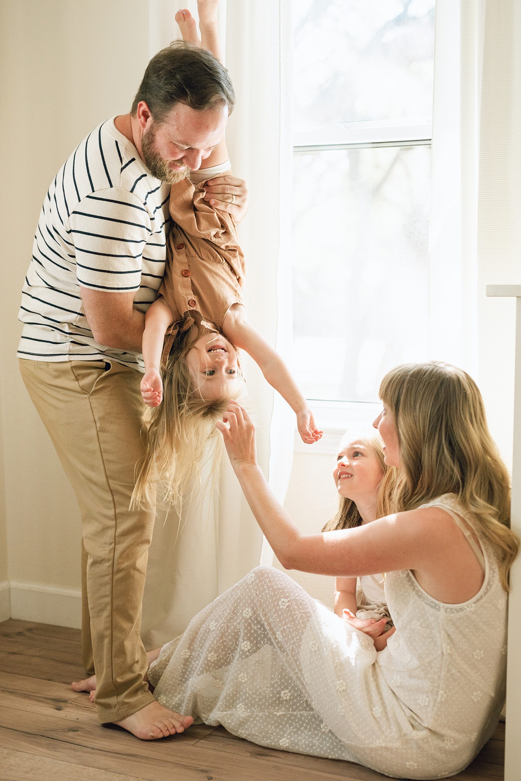 dad hangs daughter upside down by mom