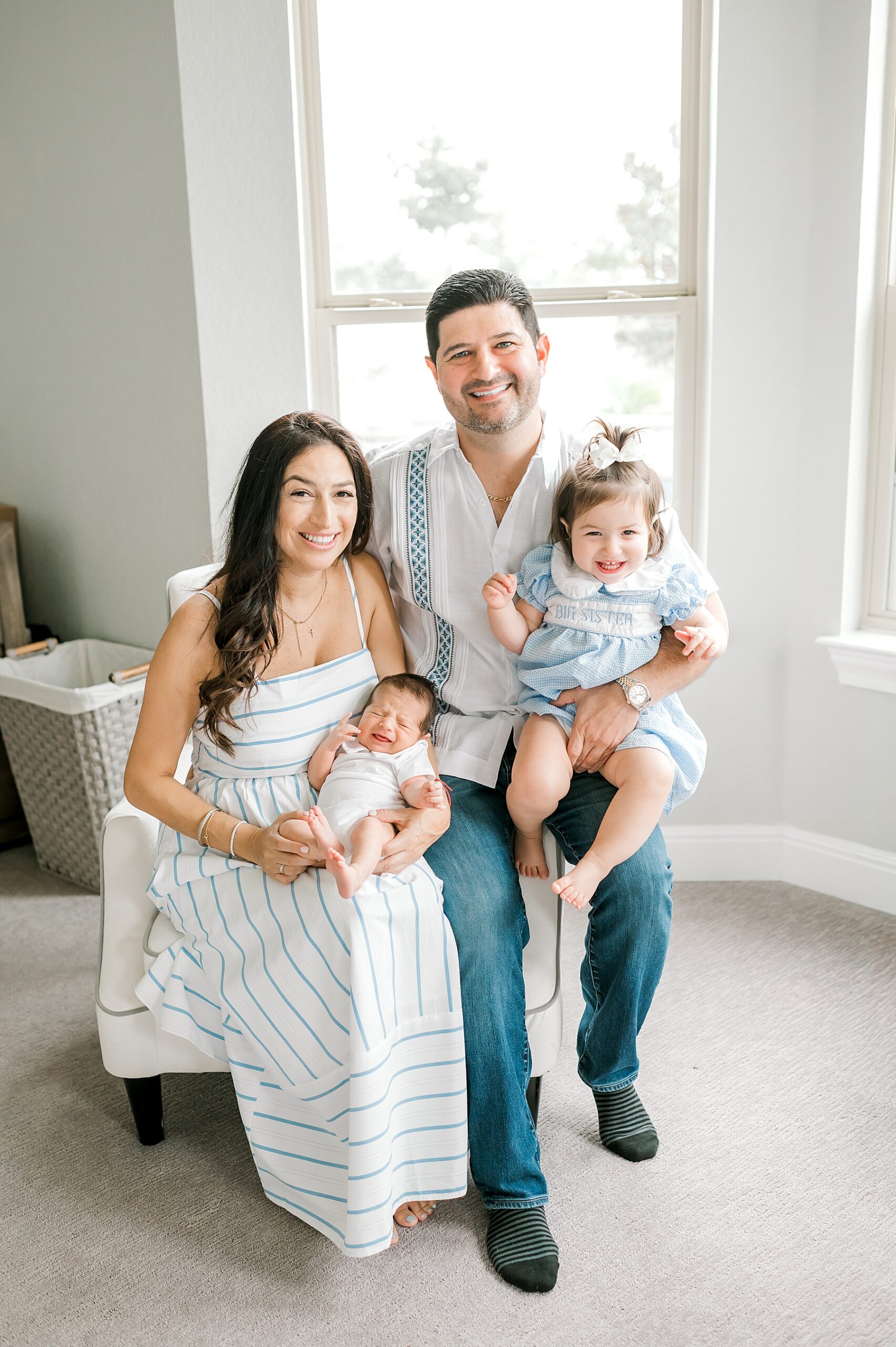 parents hold their young children during light and airy in-home newborn family session