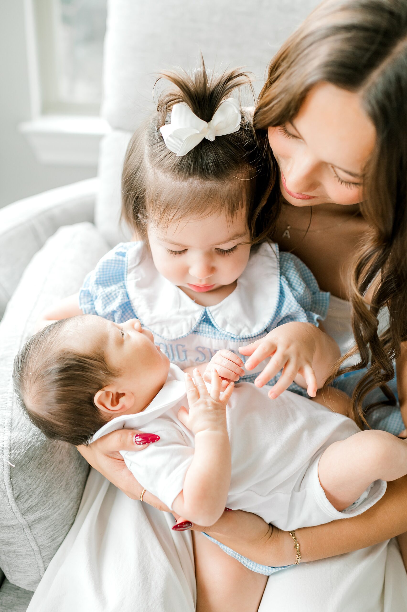 mom holds daughter and newborn son in arms