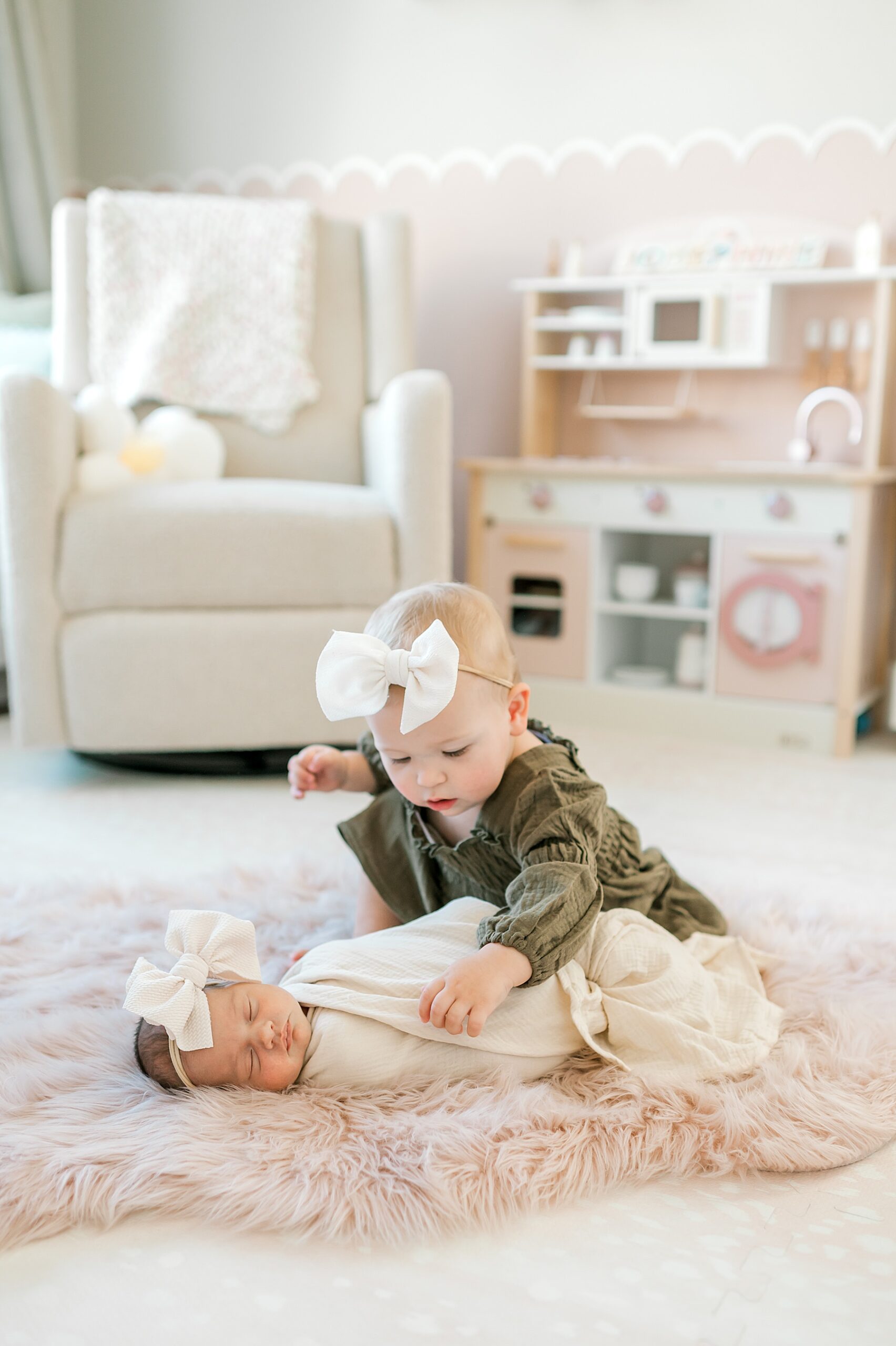 big sister lovingly checks on baby sister
