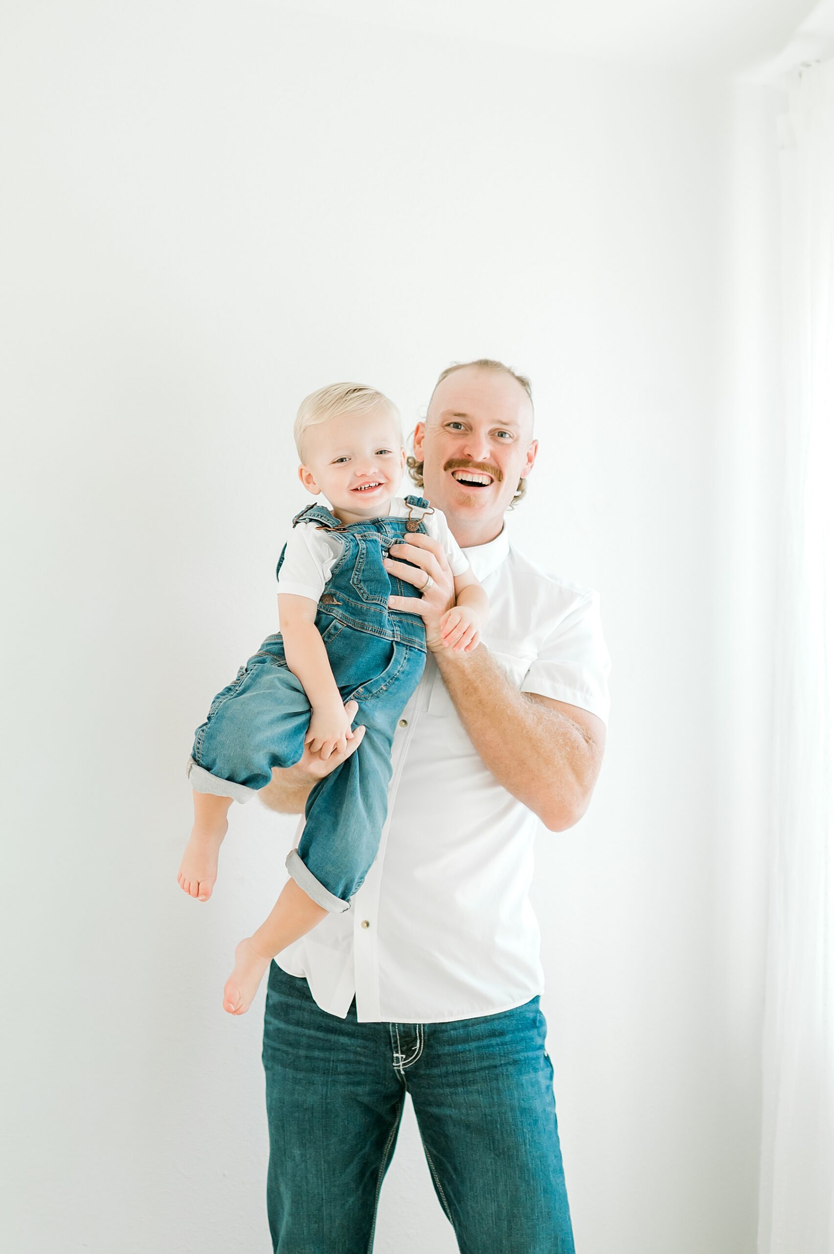 father holds his son during family session
