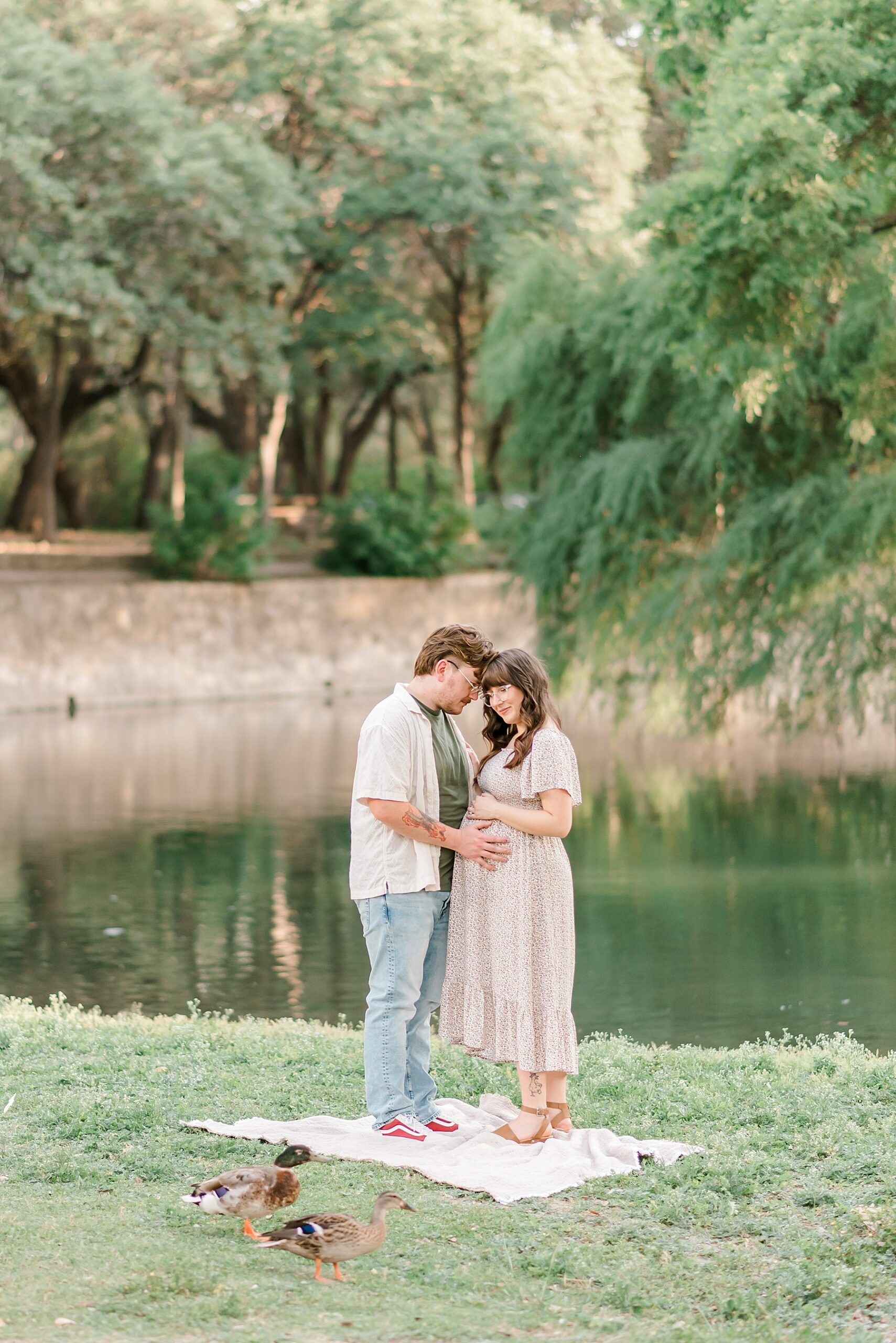 expectant parents by water during park maternity session