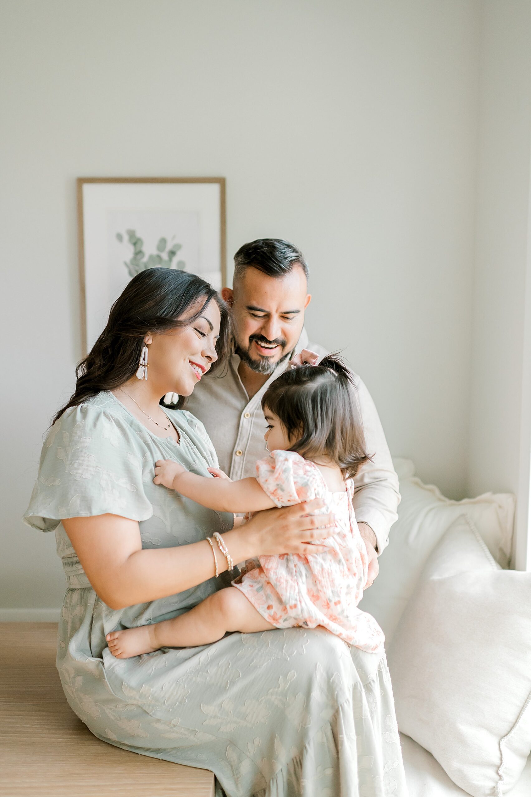mom sits with little girl on her lap