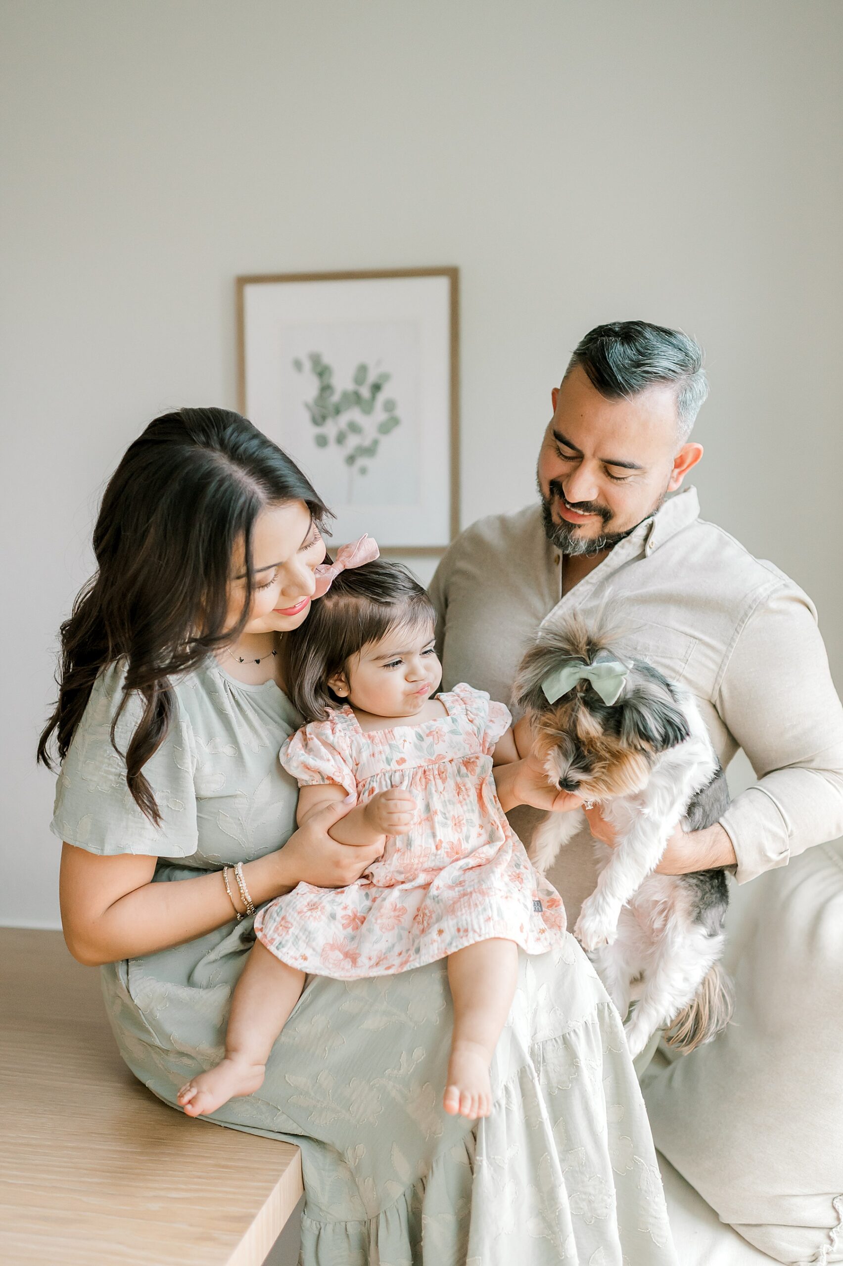 family sits together petting their dog