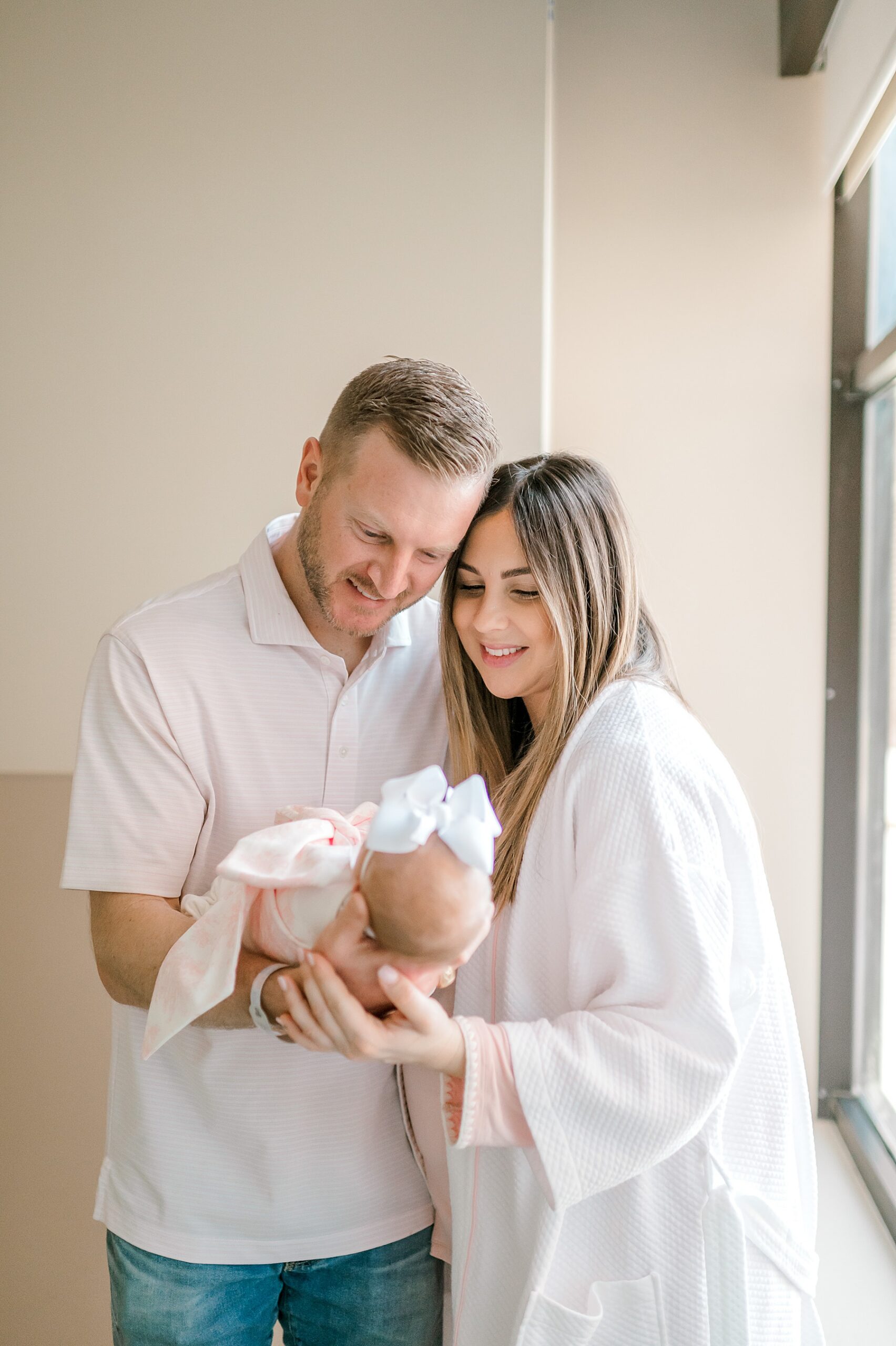 parents look down at newborn | Fresh 48 vs In-Home Newborn Session: What’s the Difference?