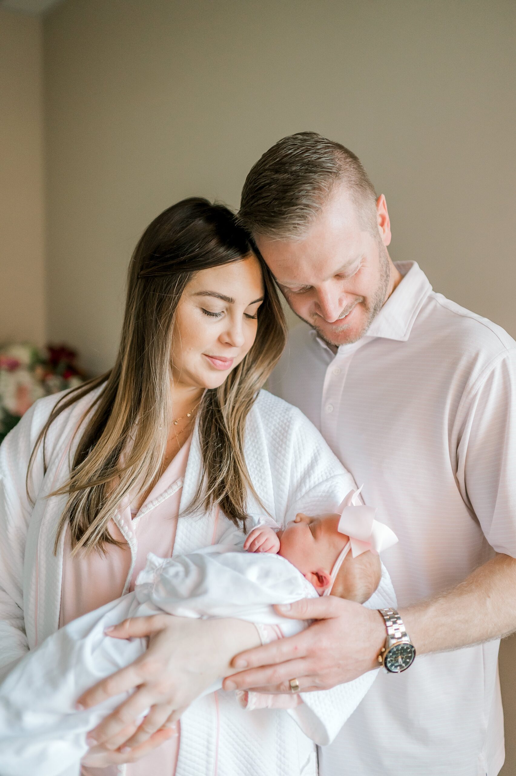 parents look down at newborn girl | Fresh 48 vs In-Home Newborn Session: What’s the Difference?