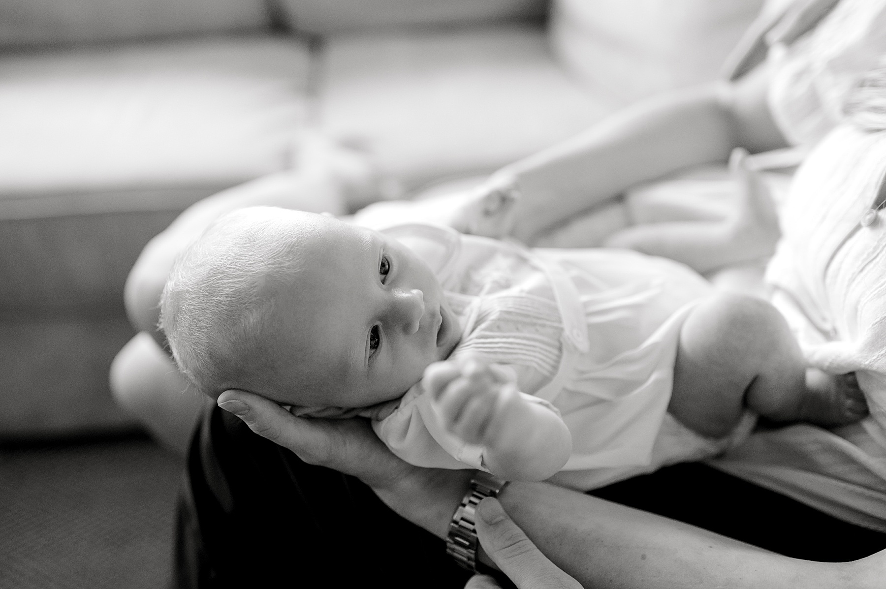 newborn laying in parents' lap