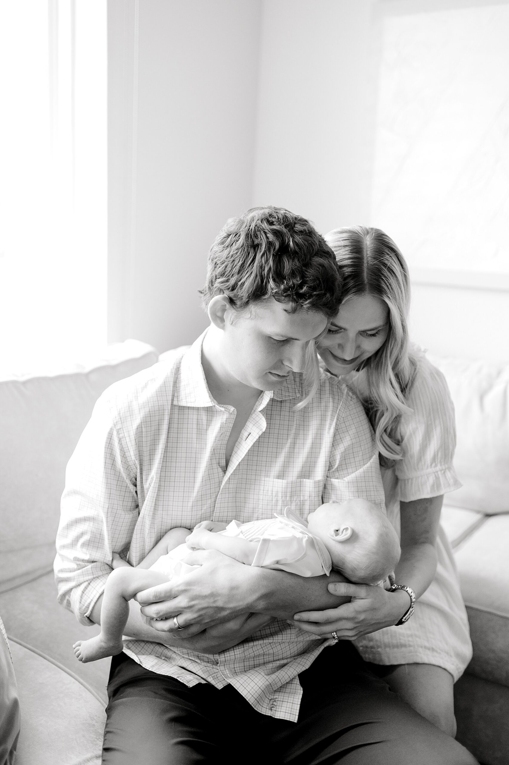 timeless portraits of parents looking down at newborn 
