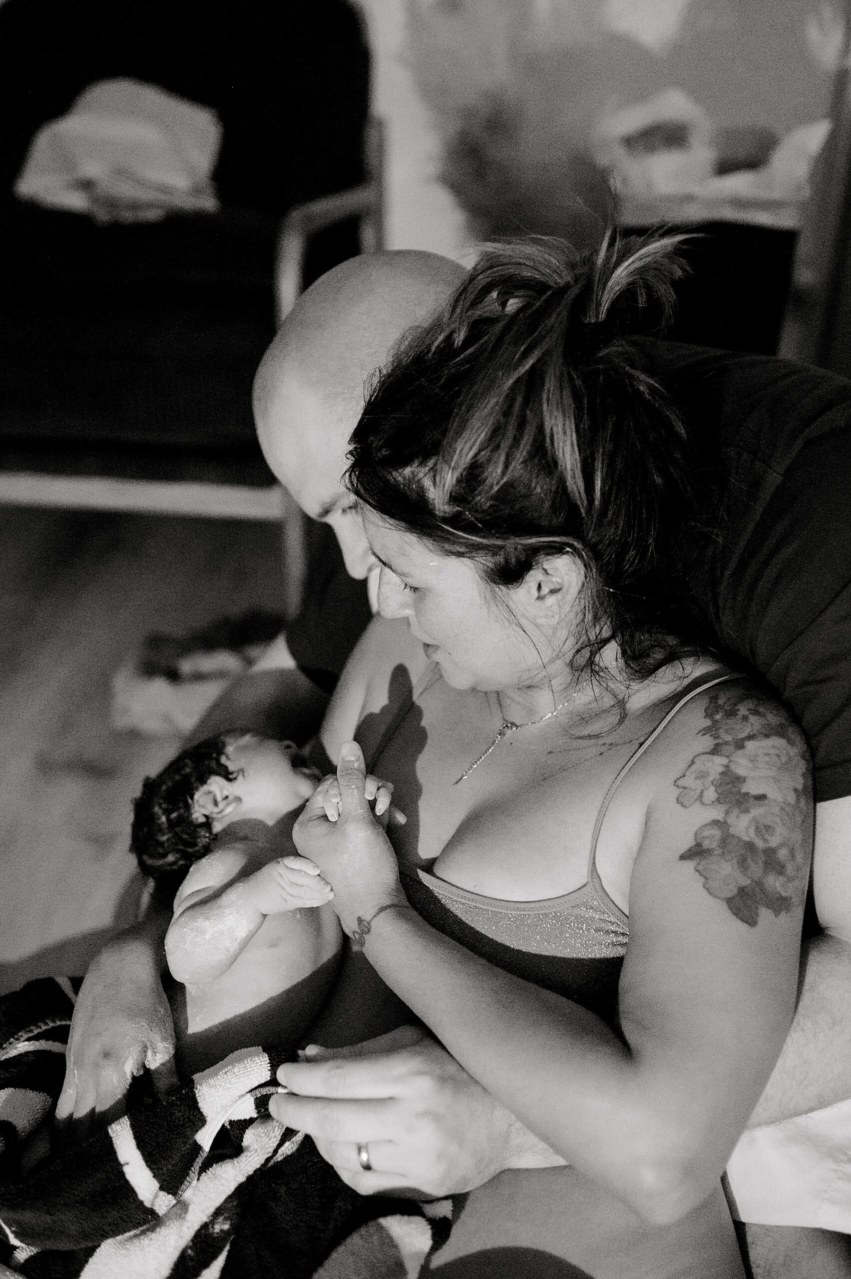 new parents hold baby girl after birth