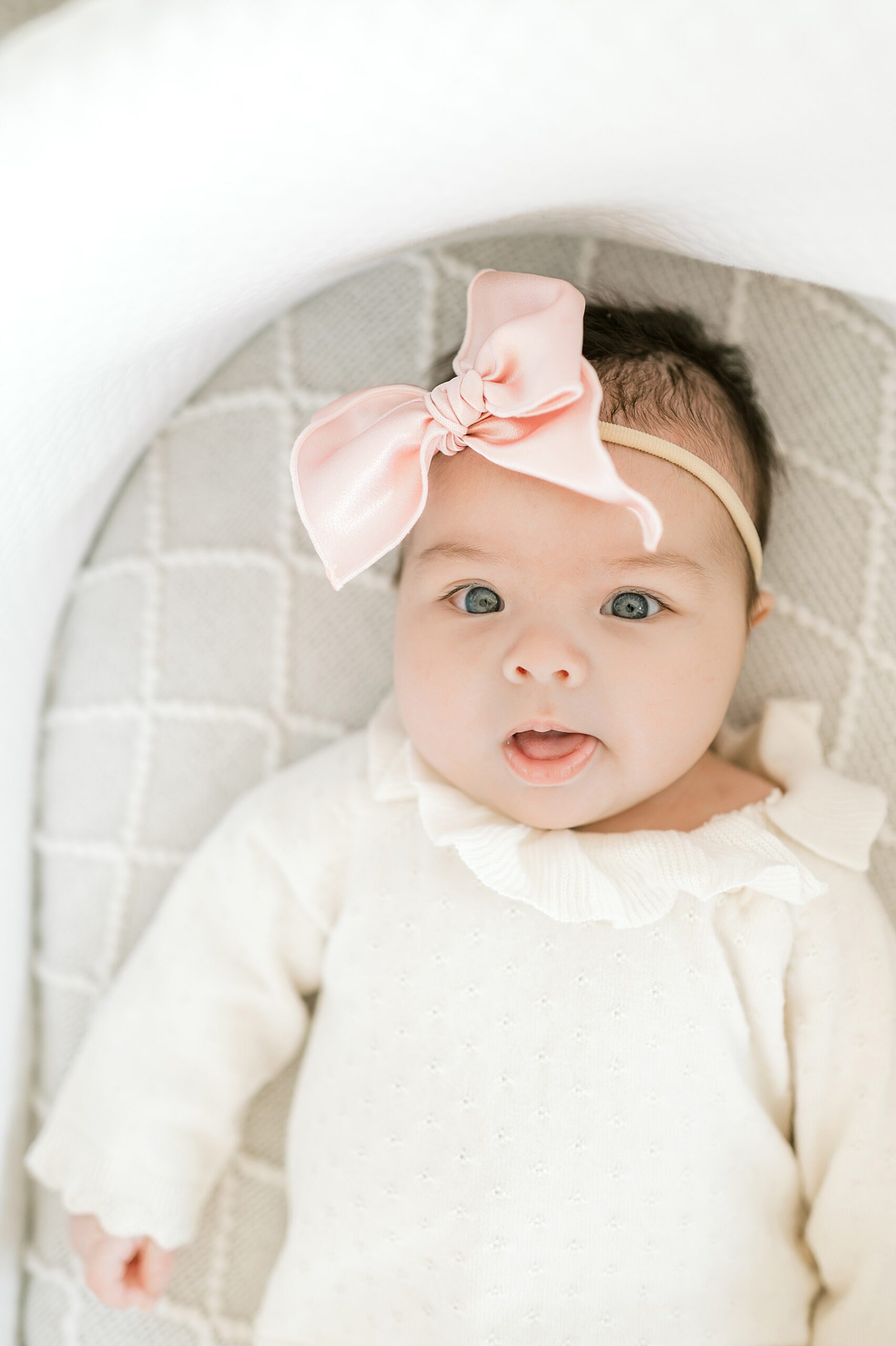 adorable newborn girl with pink bow 