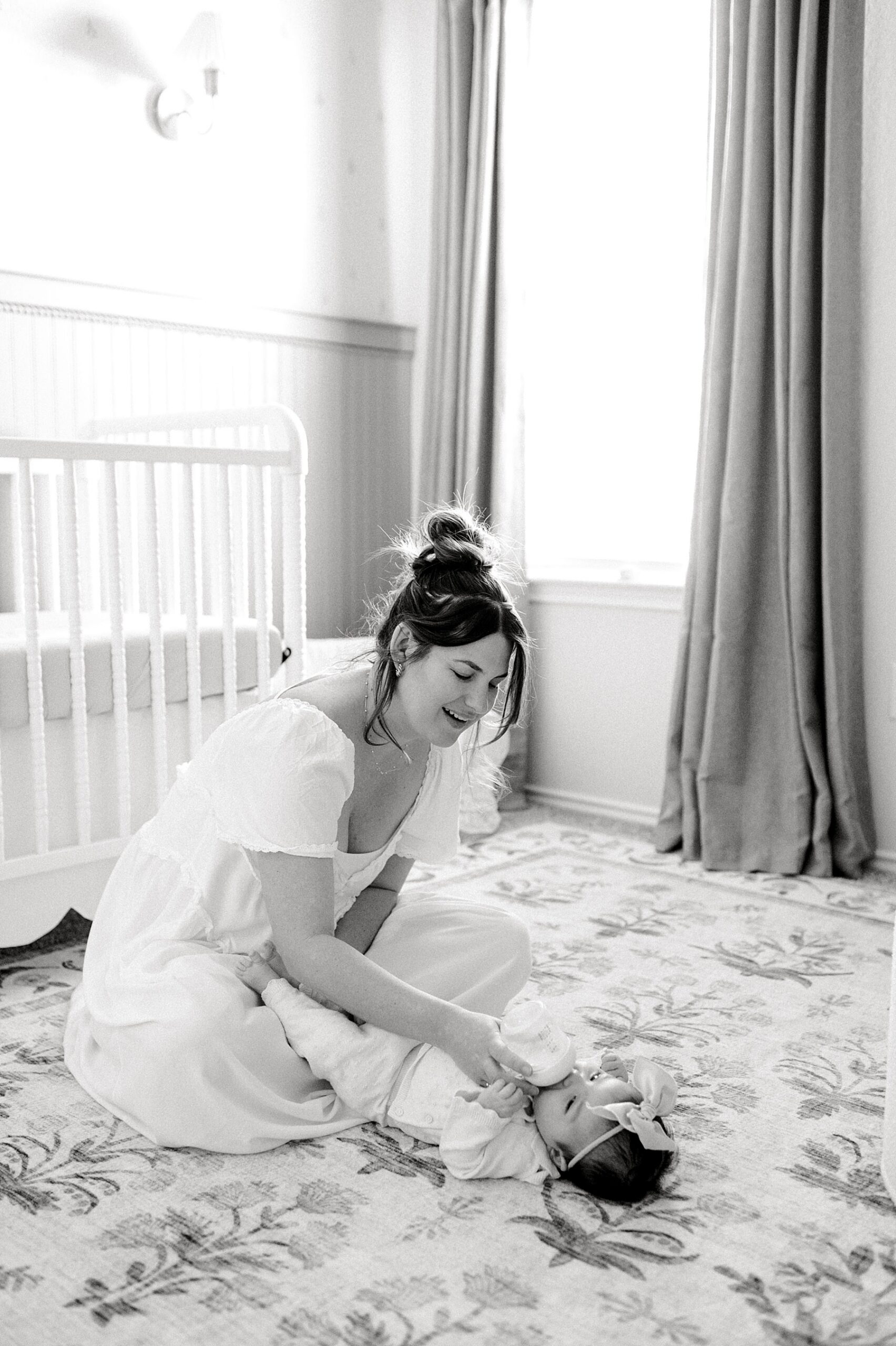 mom feeds newborn in nursery